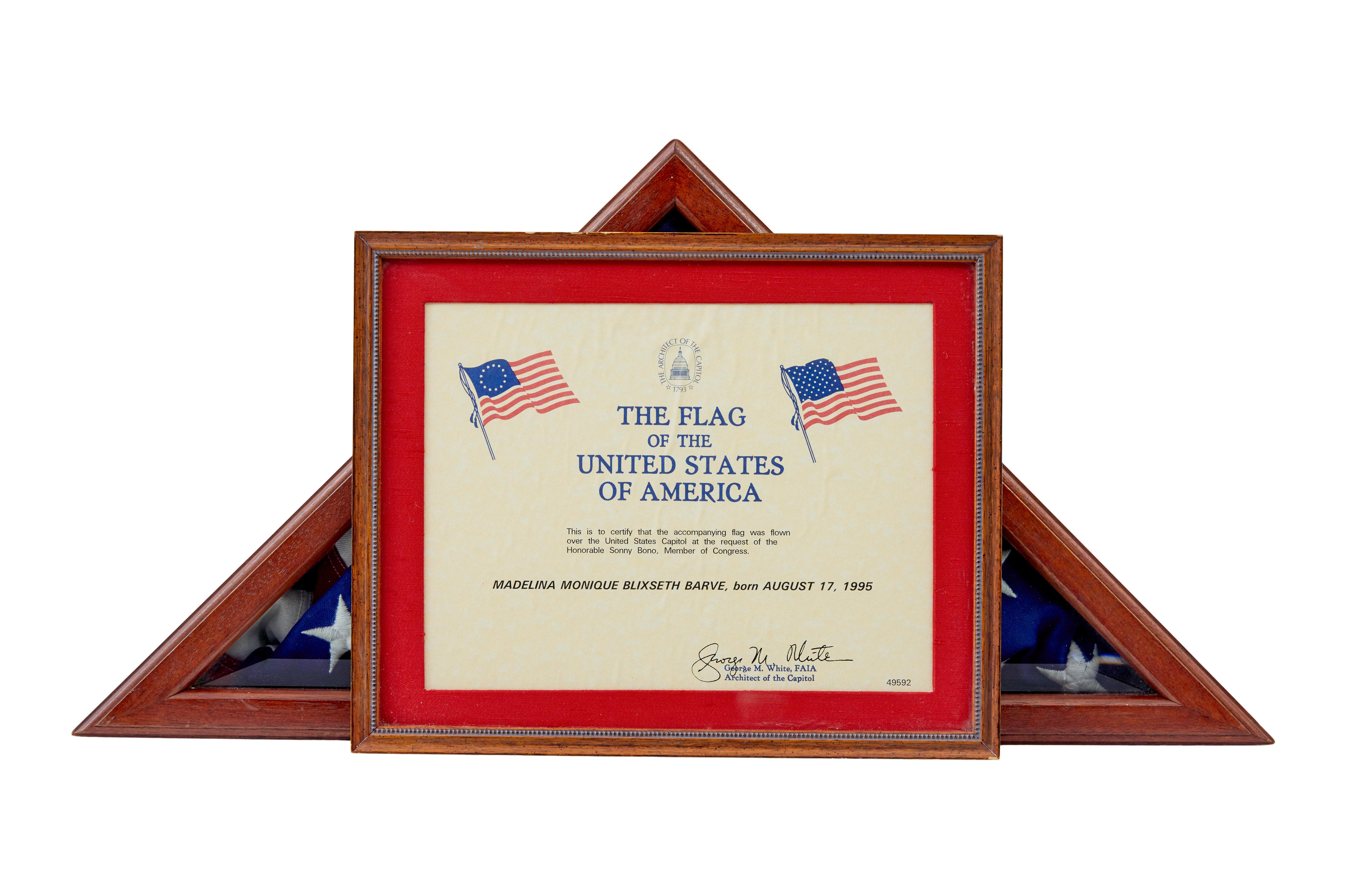 Here we present a traditionally folded American flag in mahogany glazed cabinet.

Complete with certificate to say that the flag was flown over the capital and presented by the architect of the capitol to commemorate the birth of the child on the