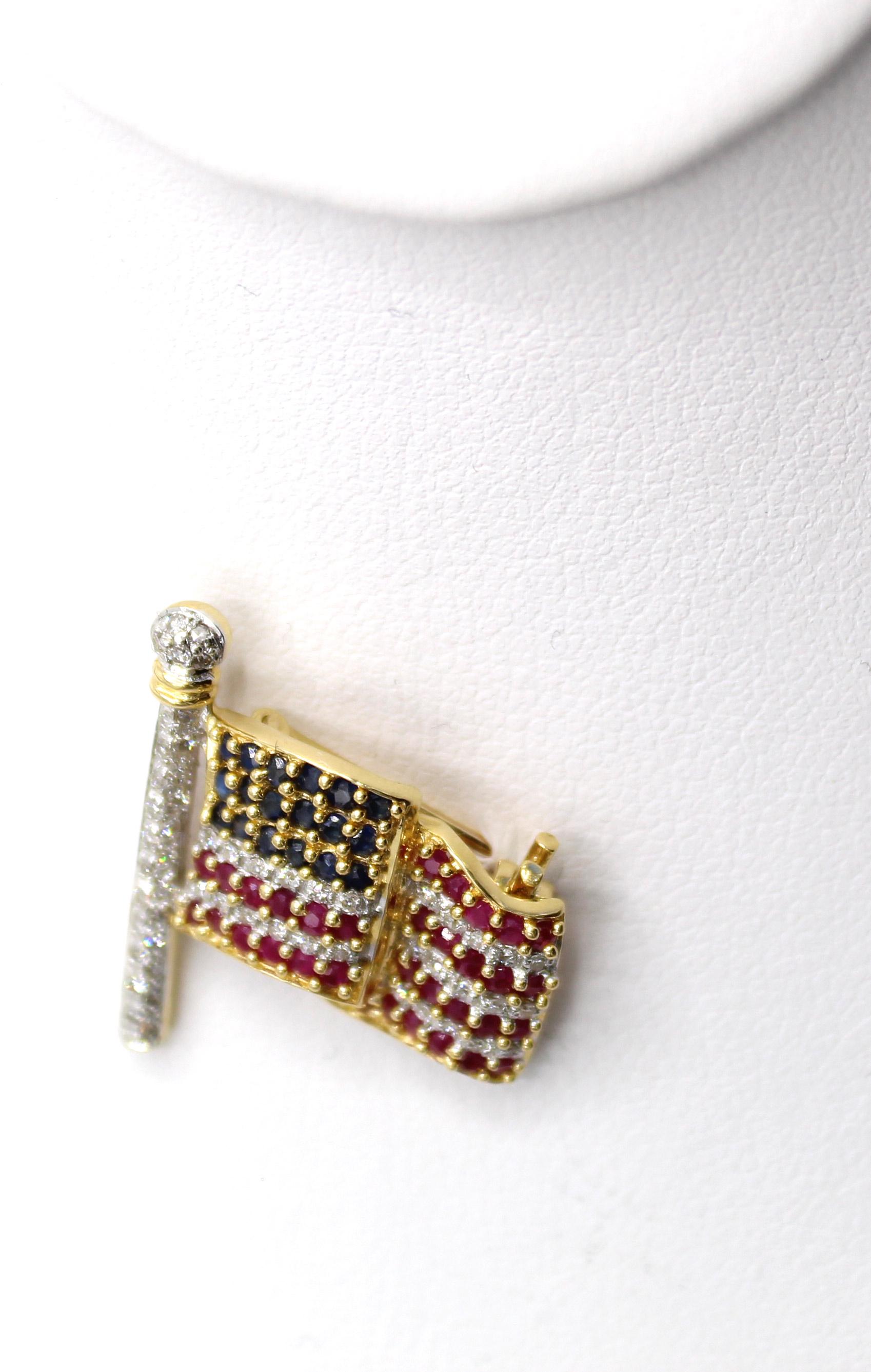 Beautifully designed and masterfully handcrafted this American flag pin seems to be flowing in the wind. Set with matched round diamonds, sapphires and rubies, all in 18 karat white and yellow gold, this pin is a colorful and decorative everyday