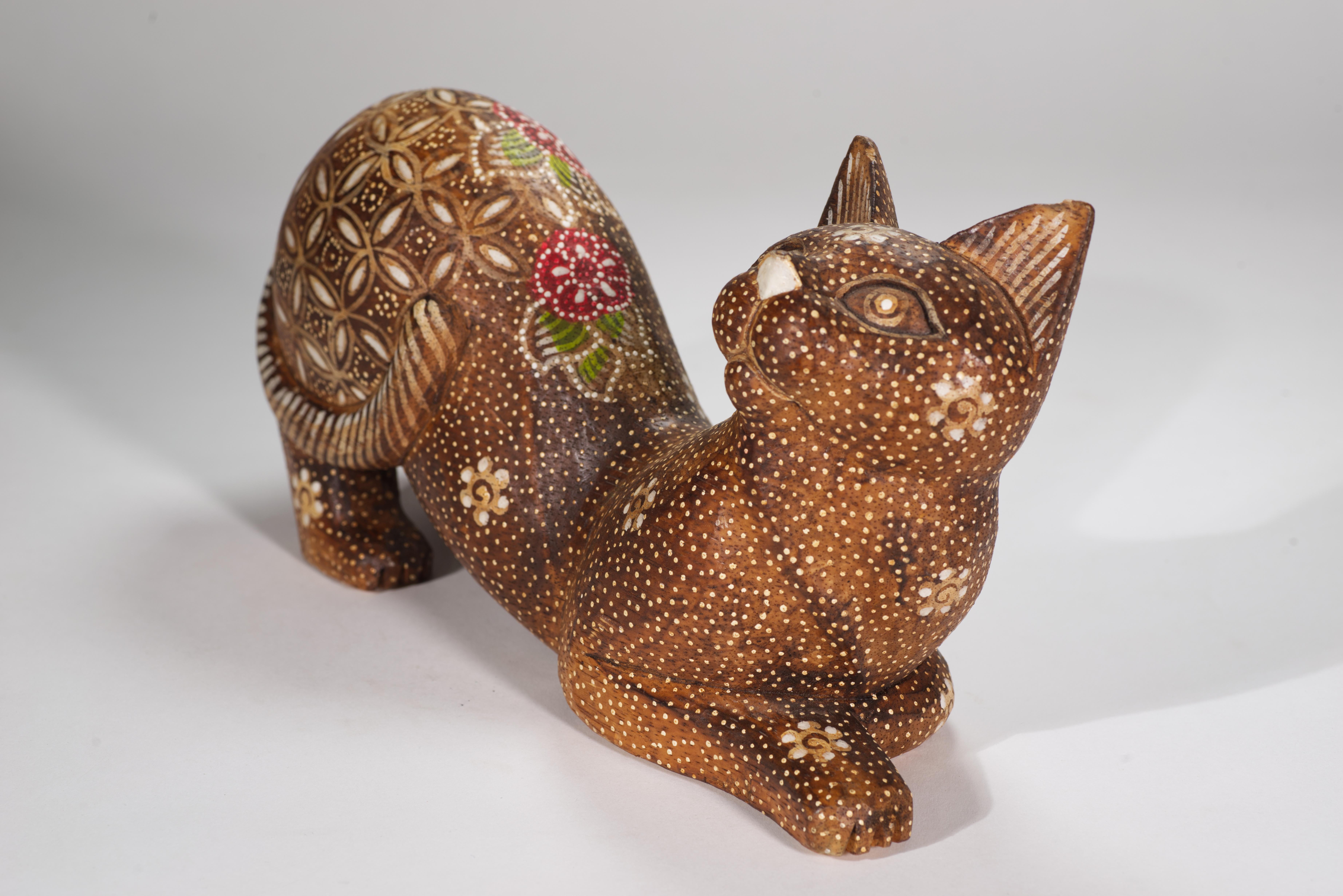  Vintage skurrile und verspielte American Folk Art handgeschnitzte Holzskulptur zeigt eine streckende Katze mit einem gehobenen ausdrucksstarken Gesicht. Die Katze hat ein wunderschönes handbemaltes Dekor im Flower-Power-Stil auf der detailliert