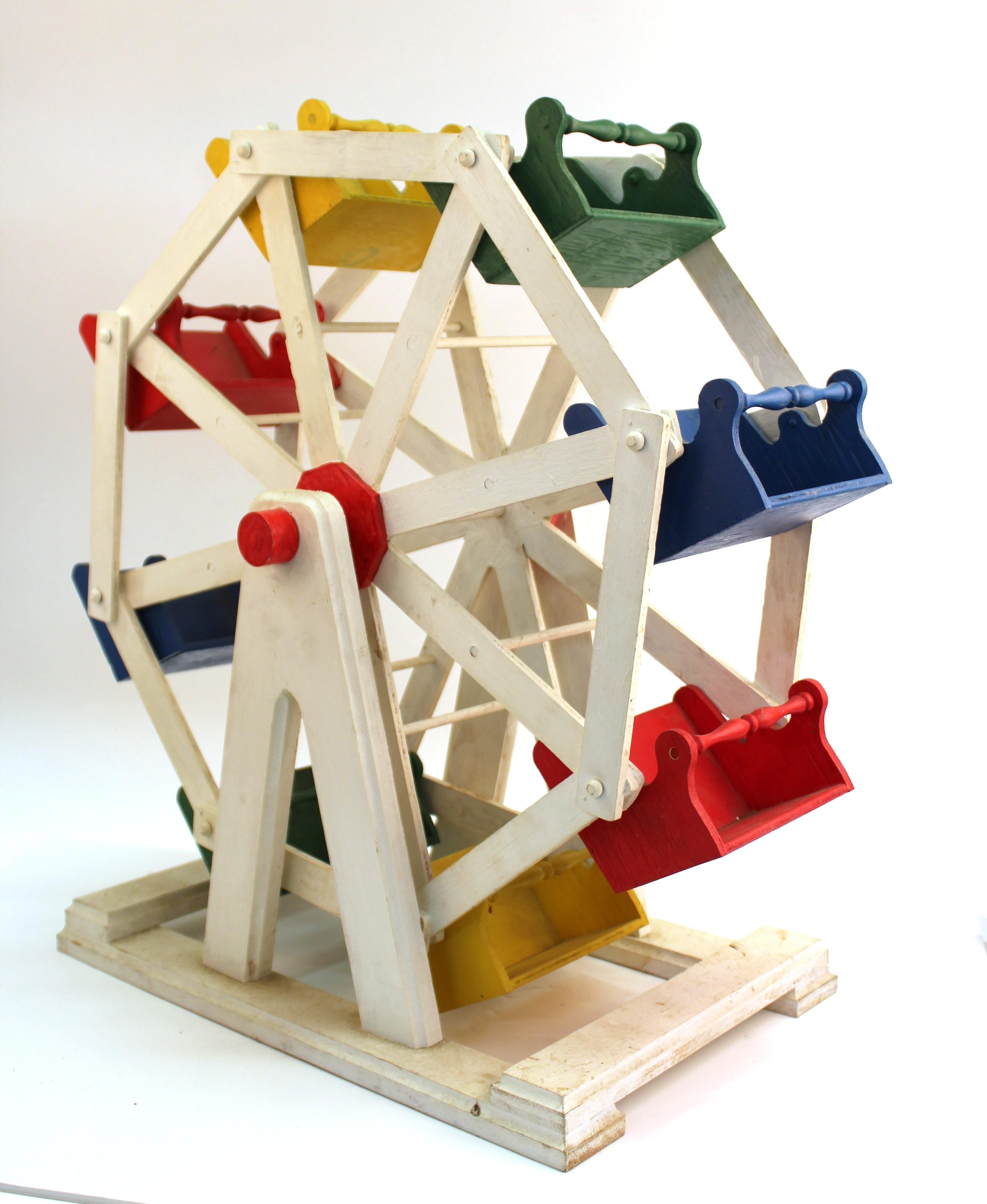American Folk Art carnival Ferris wheel scale model with hand painted colorful seats. The wheel and the individual seats move when turned. In great vintage condition with age-appropriate wear and use.