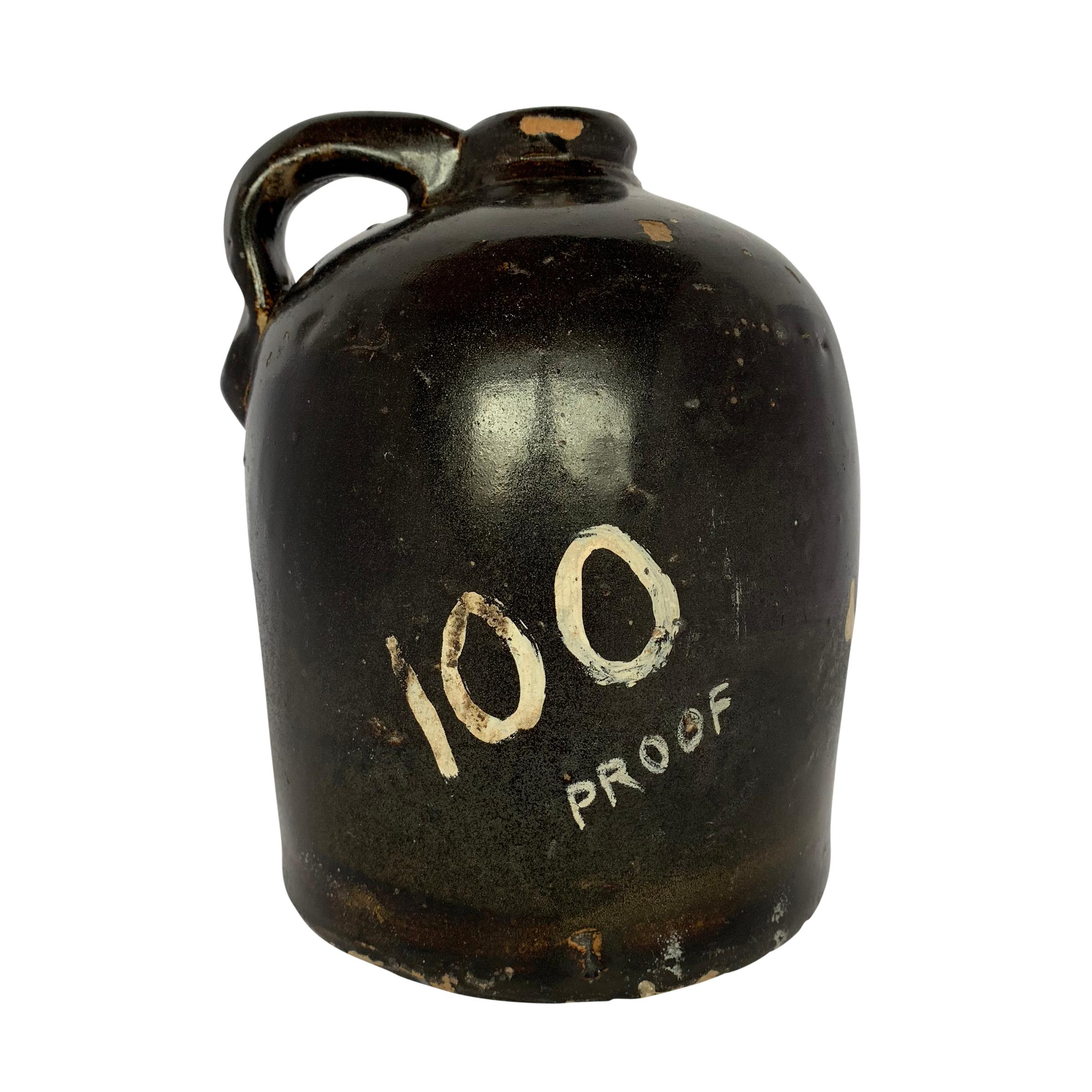 A great American 19th century Albany Slip glazed stoneware liquor jug painted with a skull and crossbones, the words “100 Proof”, and the word “Danger!”. This a really fun piece of American Folk Art.