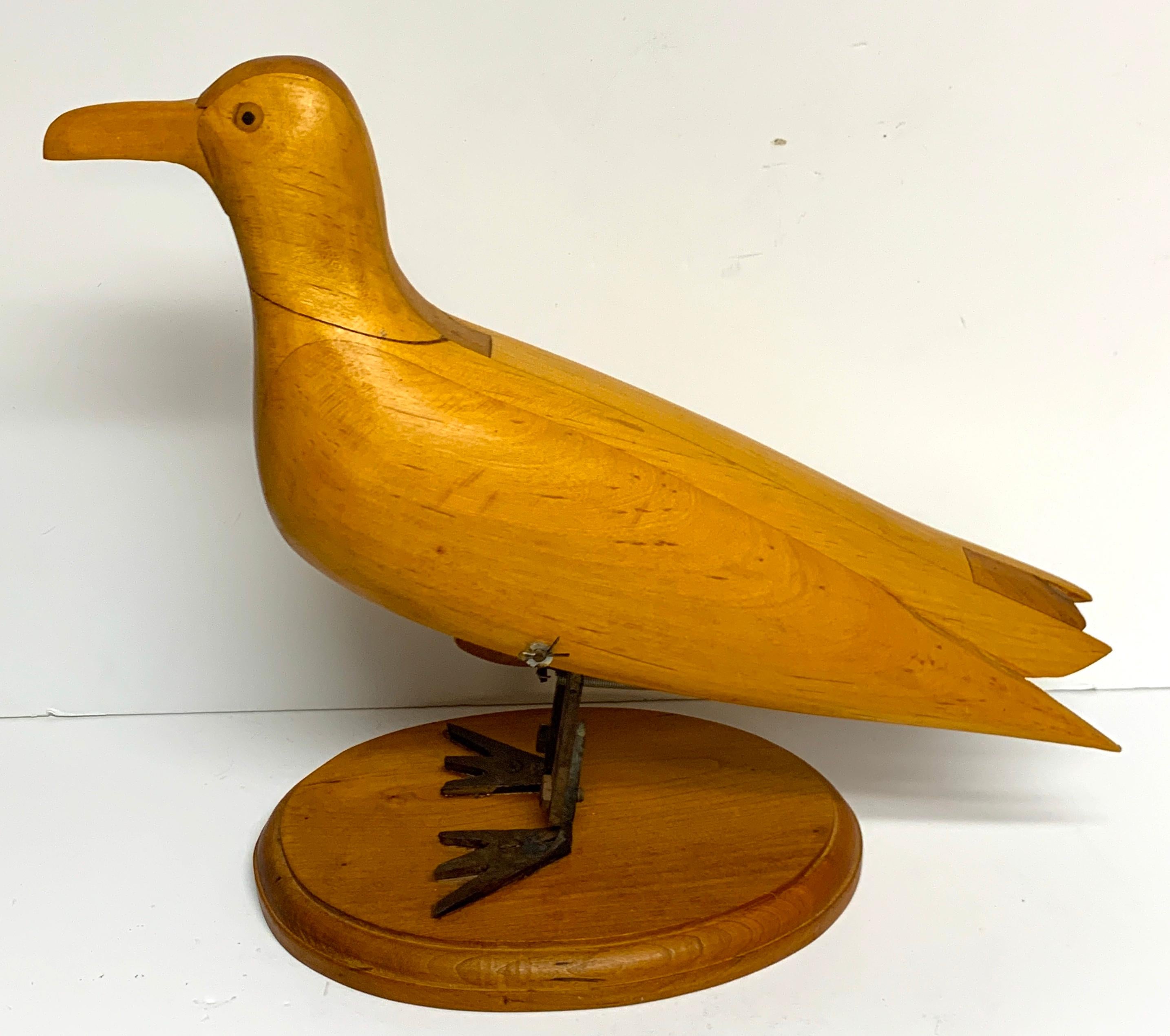American Folk Art mechanical seagull sculpture, well carved with subtly detail, the standing bird with metal legs has the ability to bend by the artisan mechanics. Unsigned, raised on an oval 9