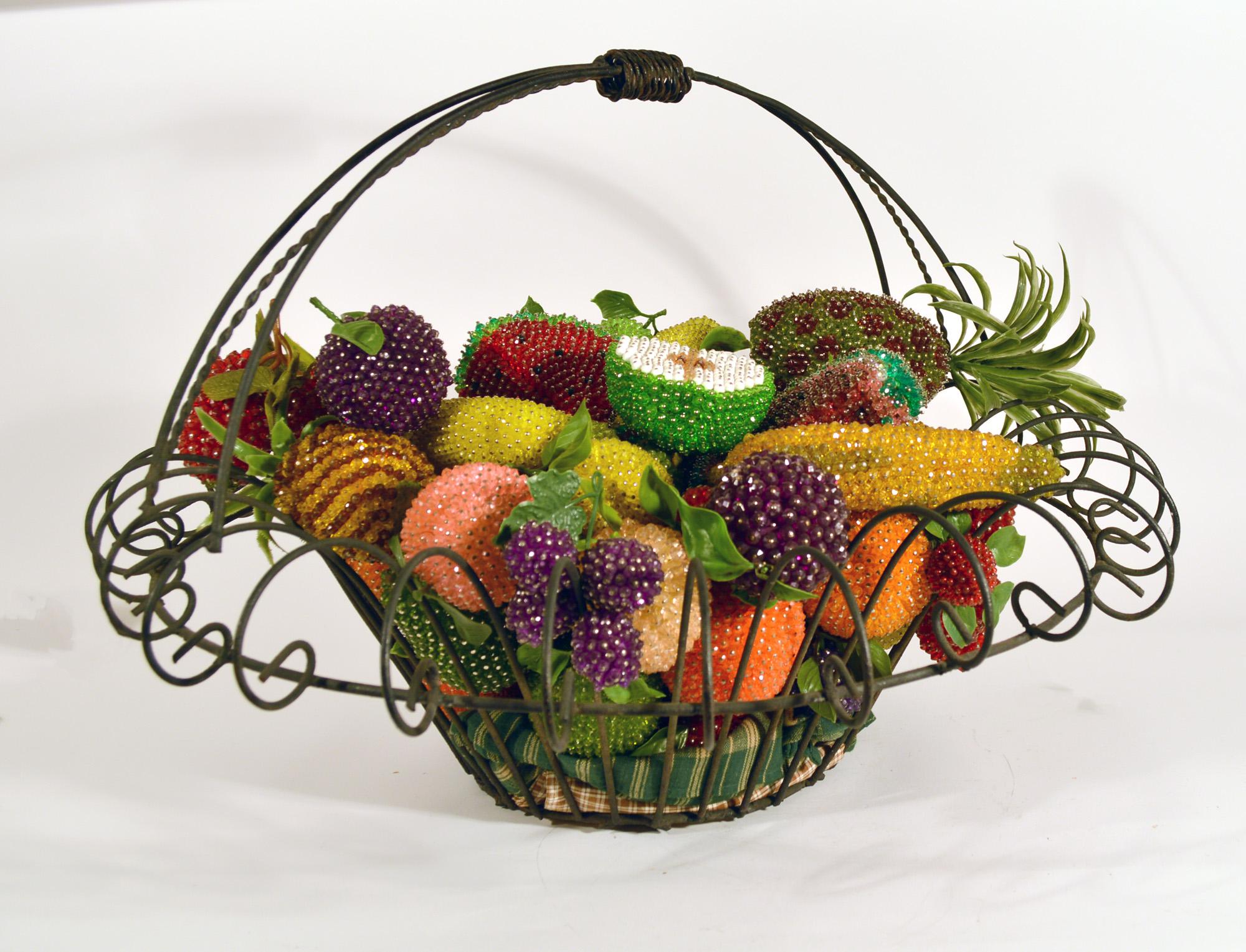 American Folk Art metal basket of beaded fruit,
Basket early 20th Century, fruit 1940s-60s.

The dramatic early 20th Century metal openwork basket contains a large collection of beaded fruit including watermelons, bananas, grapes, raspberries,
