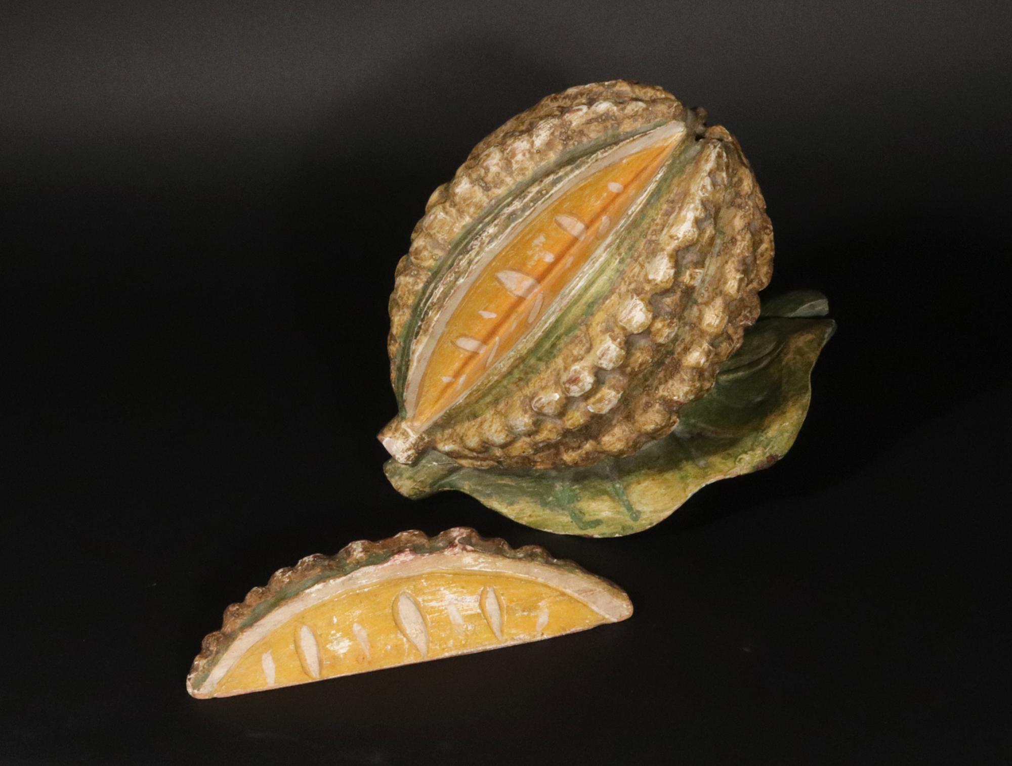 Modello di arte popolare americana di un baccello di cacao e di una sezione,
Due pezzi,
Inizio del XX secolo

Il baccello di cacao intagliato in arte popolare è modellato in modo naturalistico con due grandi foglie attaccate - vedi l'ultima foto per