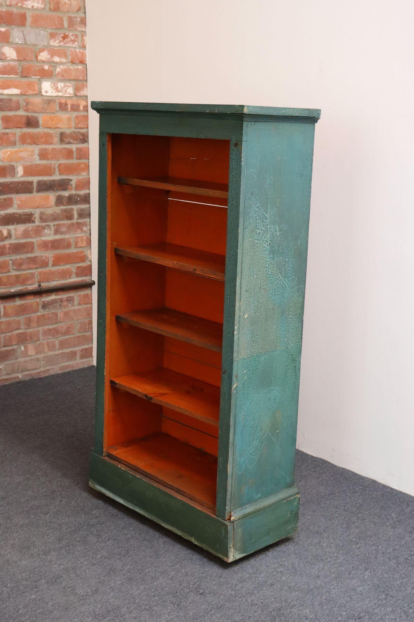 American folk art bookcase retaining its original teal and orange paint (ca. 1920, USA).
Features five removable shelves and the original caster wheels for easy mobility.
A unique piece whose design and vibrant palette pair well with various design