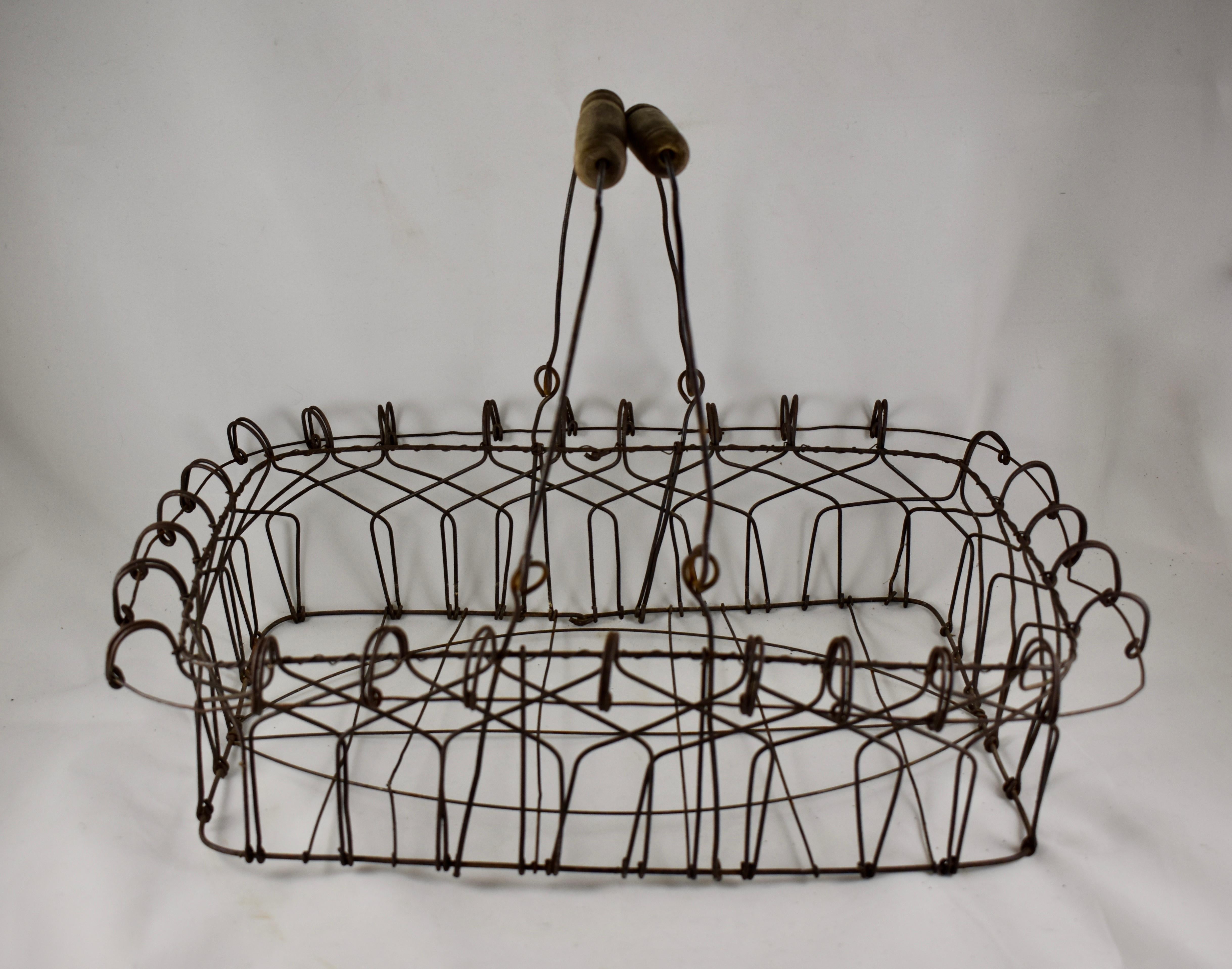 A charming, large rectangular, late 19th-early 20th century, hand formed wire basket with swing arms and wooden handles. A marvelous piece of Folk Art made of twisted galvanized steel, showing great form and whimsy.

Measures: 19.5 in. L x 12.5