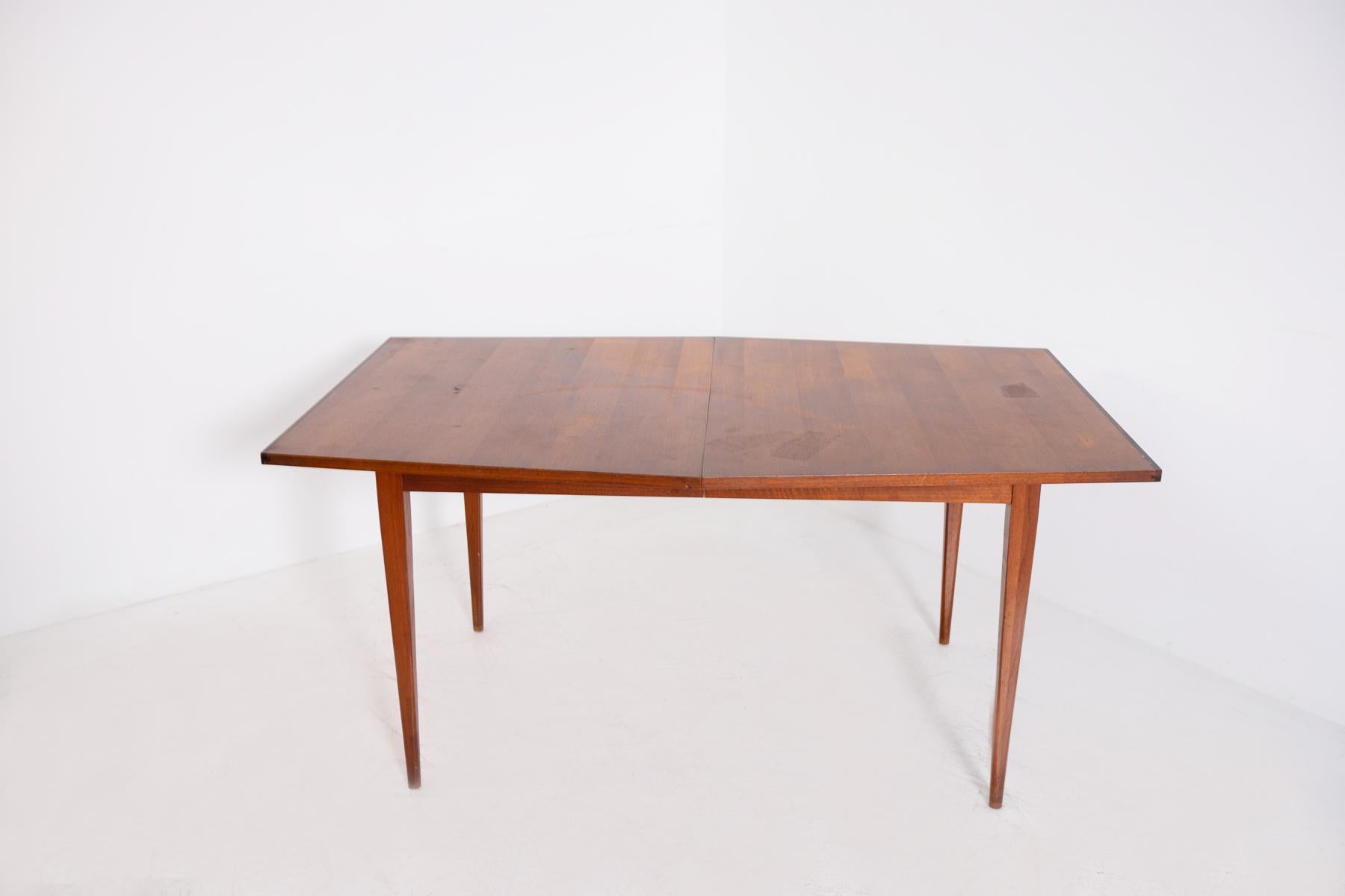 American-made geometric dining table from 1950. The table is made entirely of wood and presents interesting clean geometric shapes. Its almost hexagonal shape gives rigour and modernity to the product. Its legs, perfectly tapered in line with its