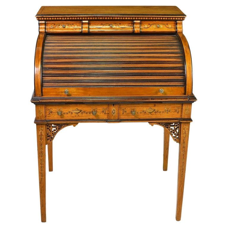 Datant de l'American Gilded Age, cette jolie table à écrire en bois satiné avec des détails ébonisés et des incrustations de marqueterie représentant les thèmes classiques de Hepplewhite, dont le muguet, le bleuet, le feuillage d'acanthe, les urnes,