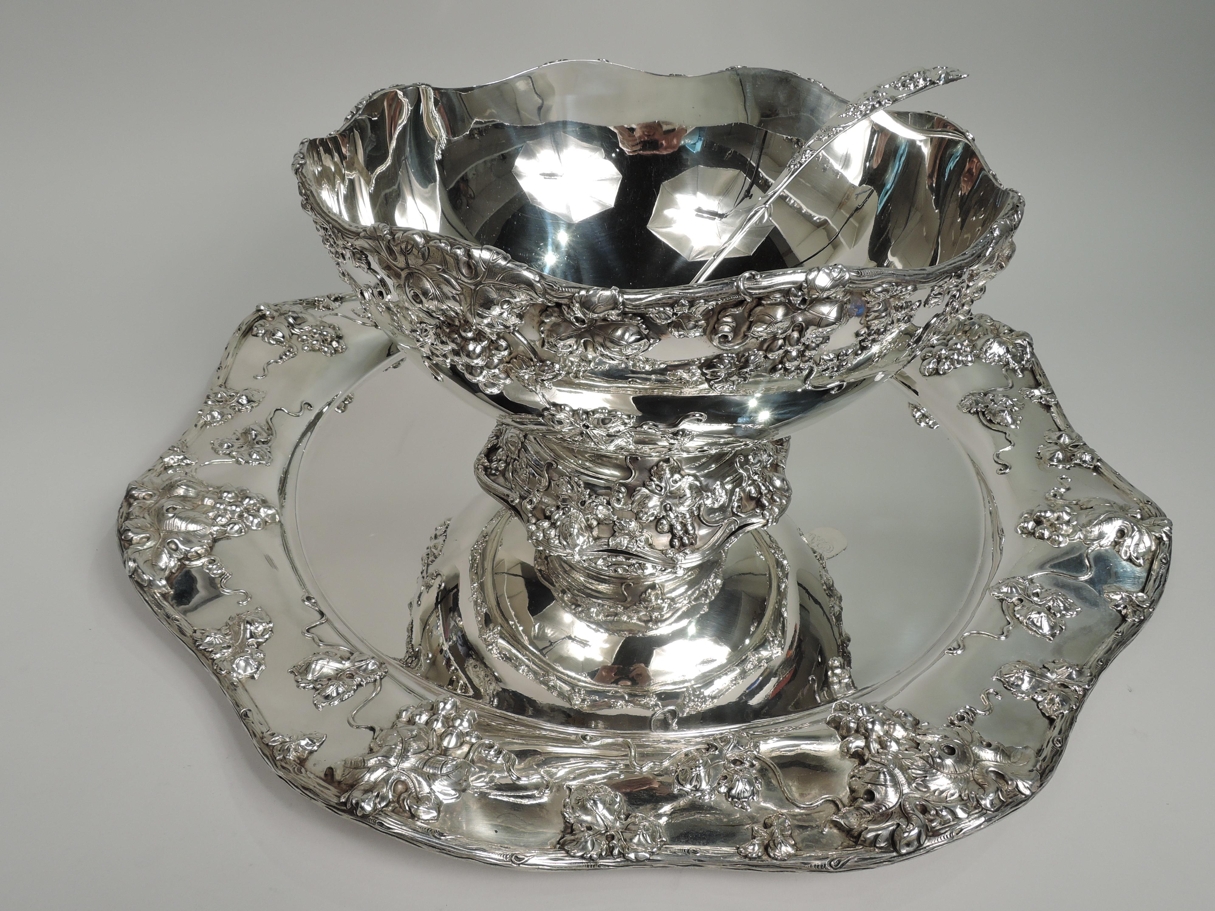 Gorgeous turn-of-the-century Gilded Age sterling silver punch bowl and ladle on stand. Made by Frank W. Smith in Gardner, Mass. Curved bowl in domed foot. Stand has plain well and wide shoulder. Applied grape bunches and leaves as well as squiggly