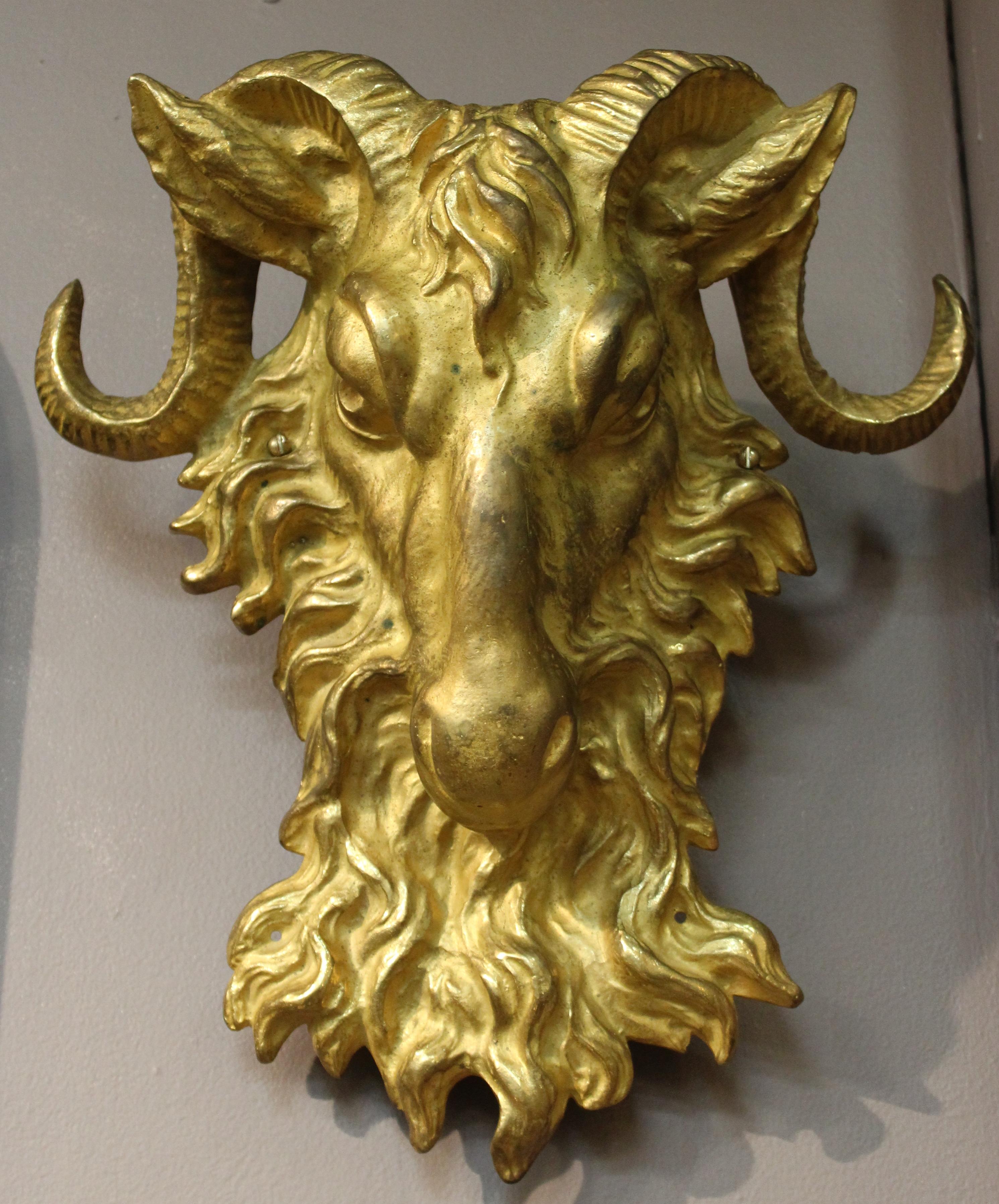 American gilded age neoclassical Revival pair of sconces made from horned ram heads, probably re-purposed from former decorative facade metal elements. The pair is in gilt bronze and can be easily mounted to a wall as sconces or be use as decorative
