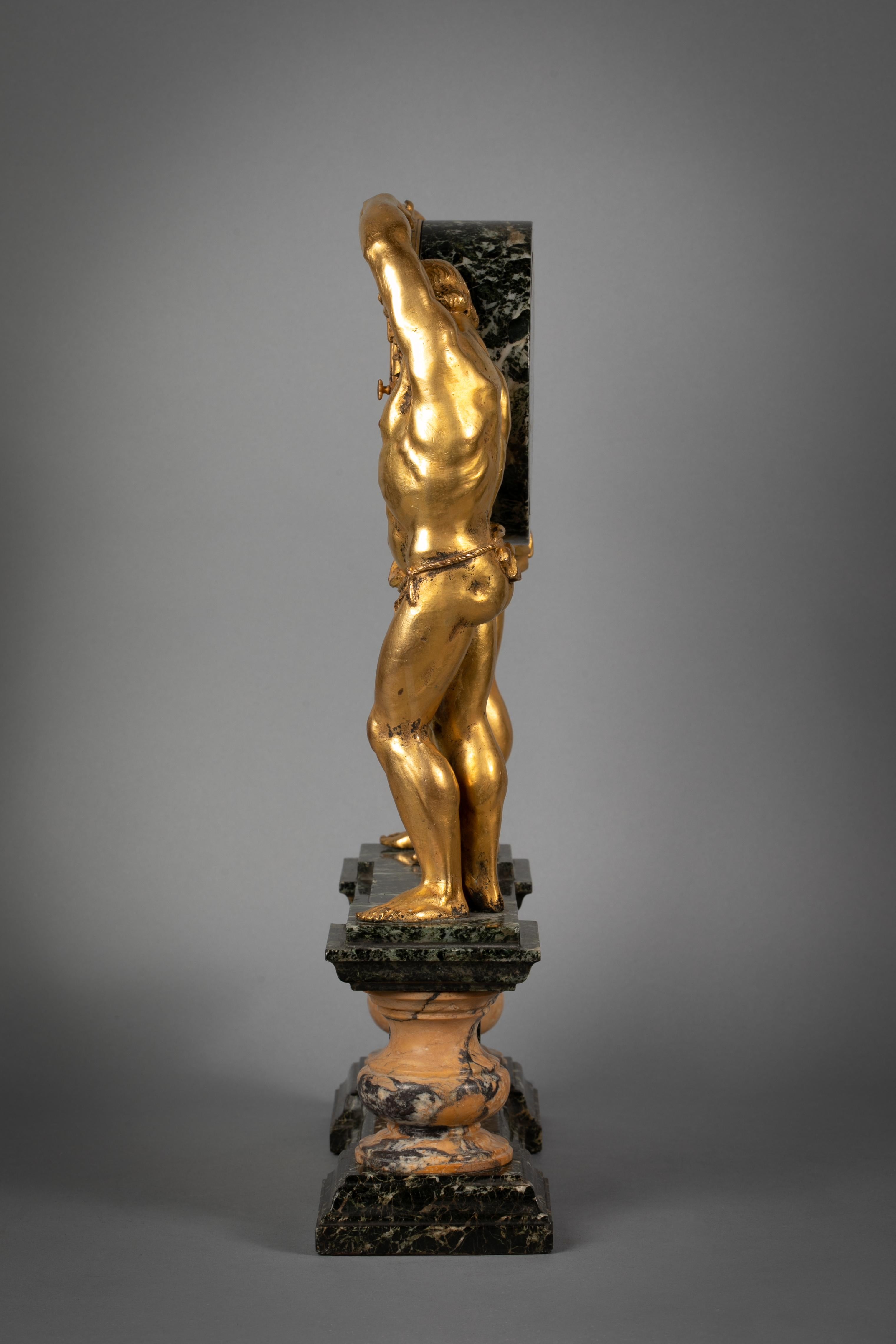 With two classical figures on a stepped markble base surmounted on a pair of yellow marble urn shaped supports, flanking a rectangular plaque with a gilt bronze bas relief of ribbons and garlands surrounding a circular plaque which reads 'Tempvs