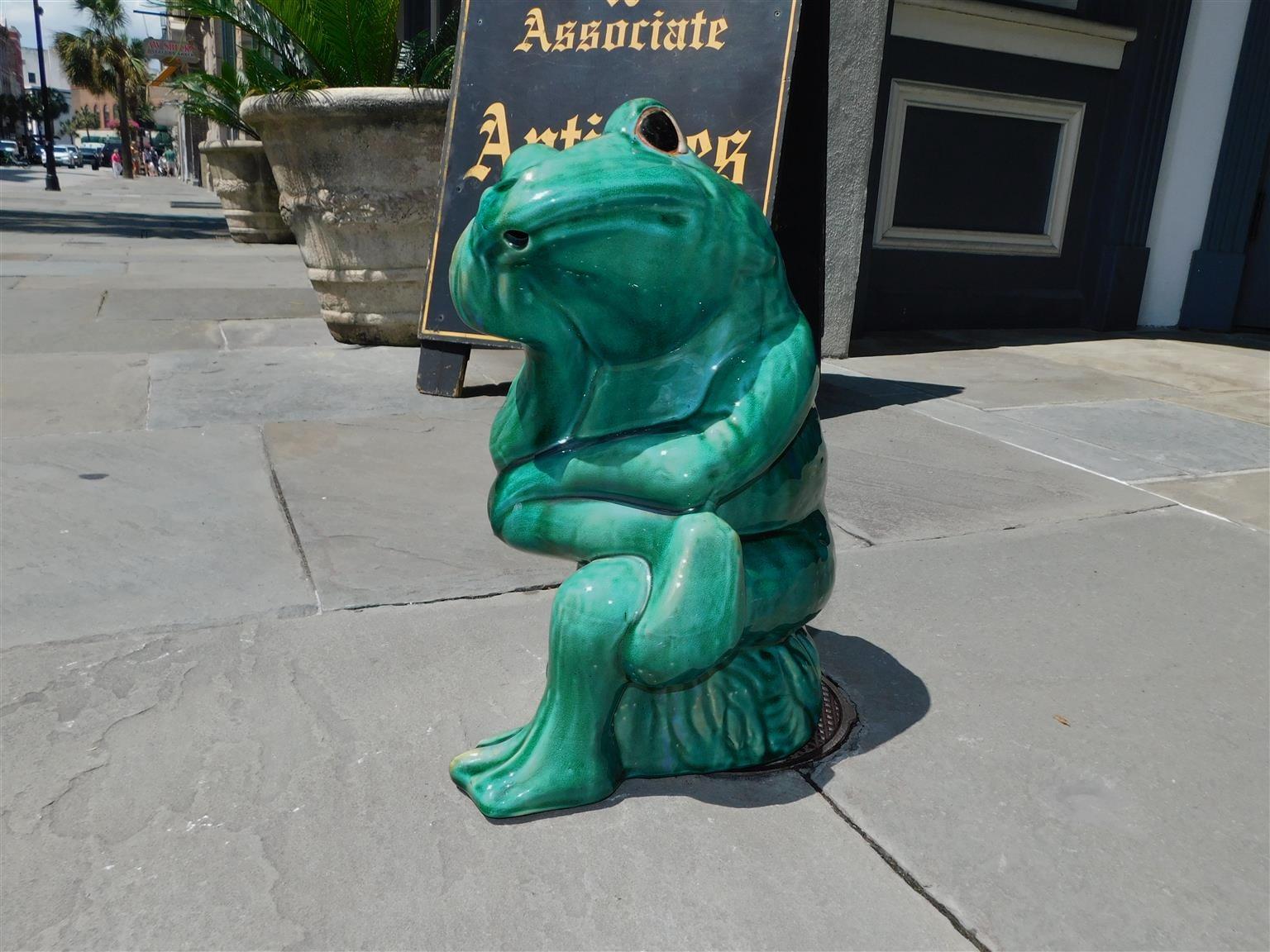 American glazed large porcelain frog fountain sitting with arms and legs crossed on lily pad stump while pondering life. Frog has exterior water spout on mouth. 20th Century