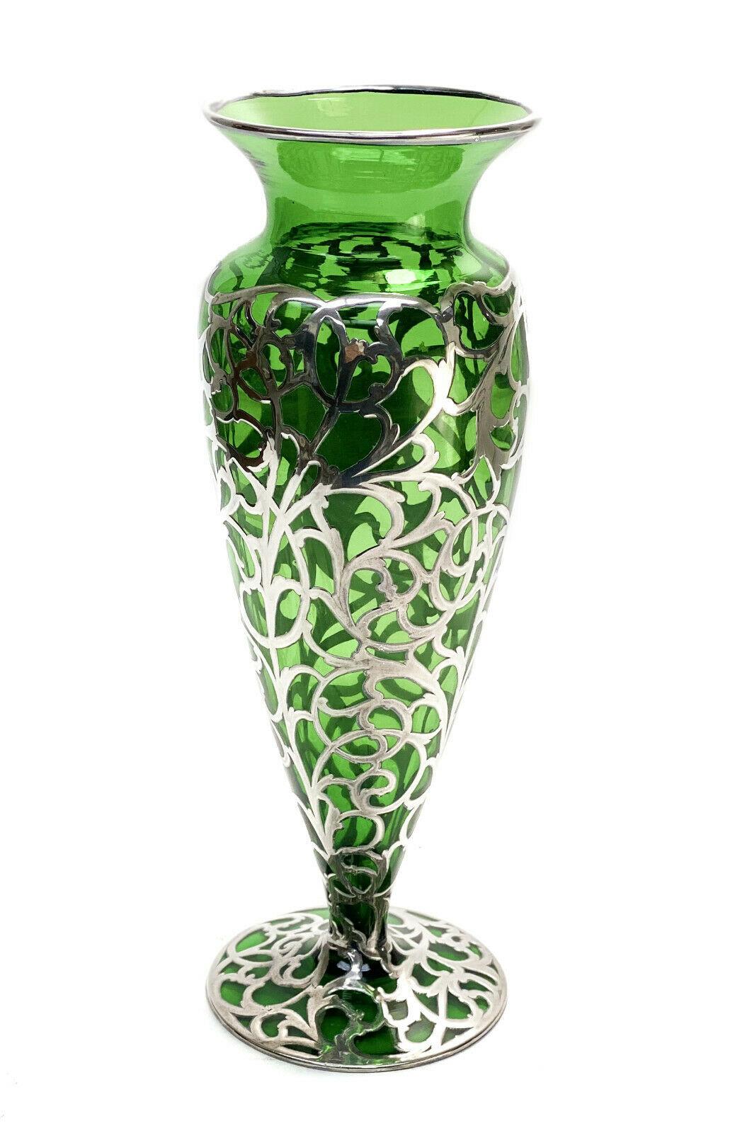American green glass silver overlay footed 12 Inch Vase, circa 1900

Green hue to the glass with foliate scroll designs throughout. Monogrammed 