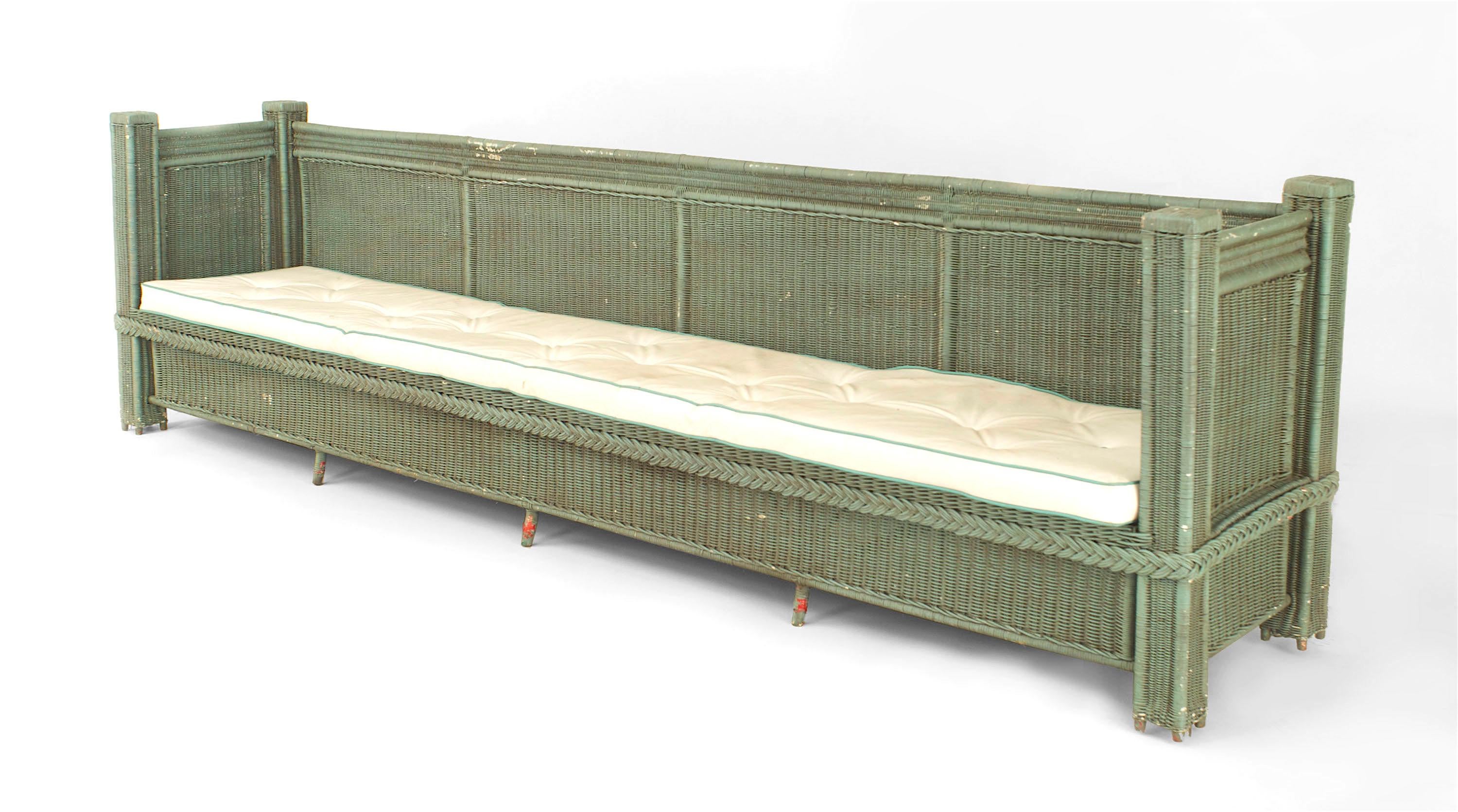 American green painted extend settee with a square woven panel back, sides, and apron with a single cushion.