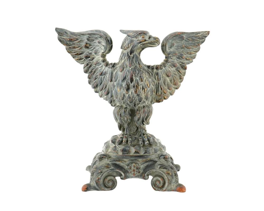Un'aquila americana intagliata a mano in legno sulla base, sapientemente lavorata per catturare la sua potente presenza. Alto su una base ornata, questo pezzo presenta dettagli intricati. La statuetta mostra una straordinaria miscela di artigianato