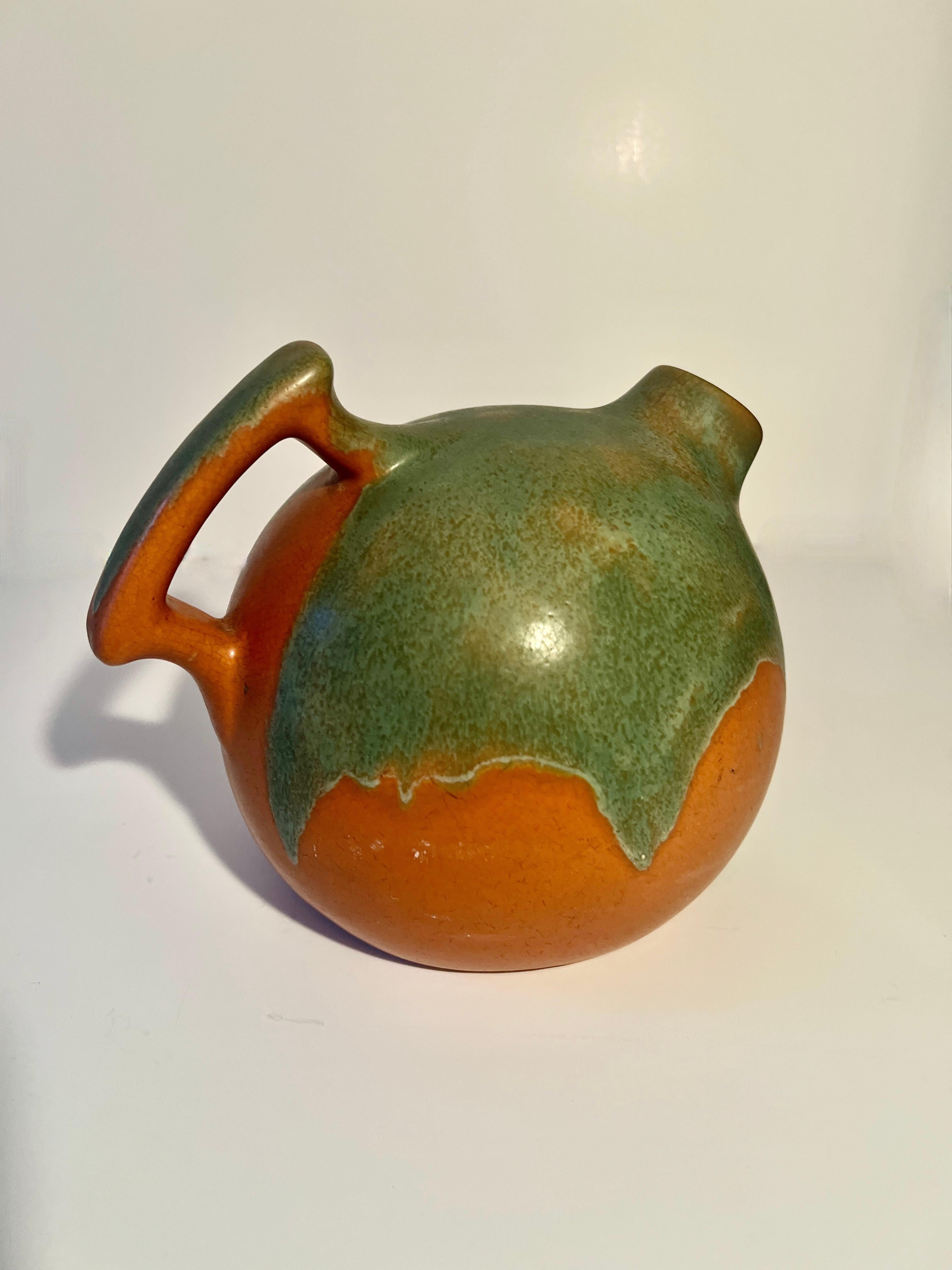 Maravillosa jarra de terracota hecha a mano, de color terroso y con un acento verde.  La jarra es redonda y tiene un asa grácil.  Listo para todo, desde zumos a cócteles, pasando por regar las plantas.

Un complemento para un bar, una mesa de
