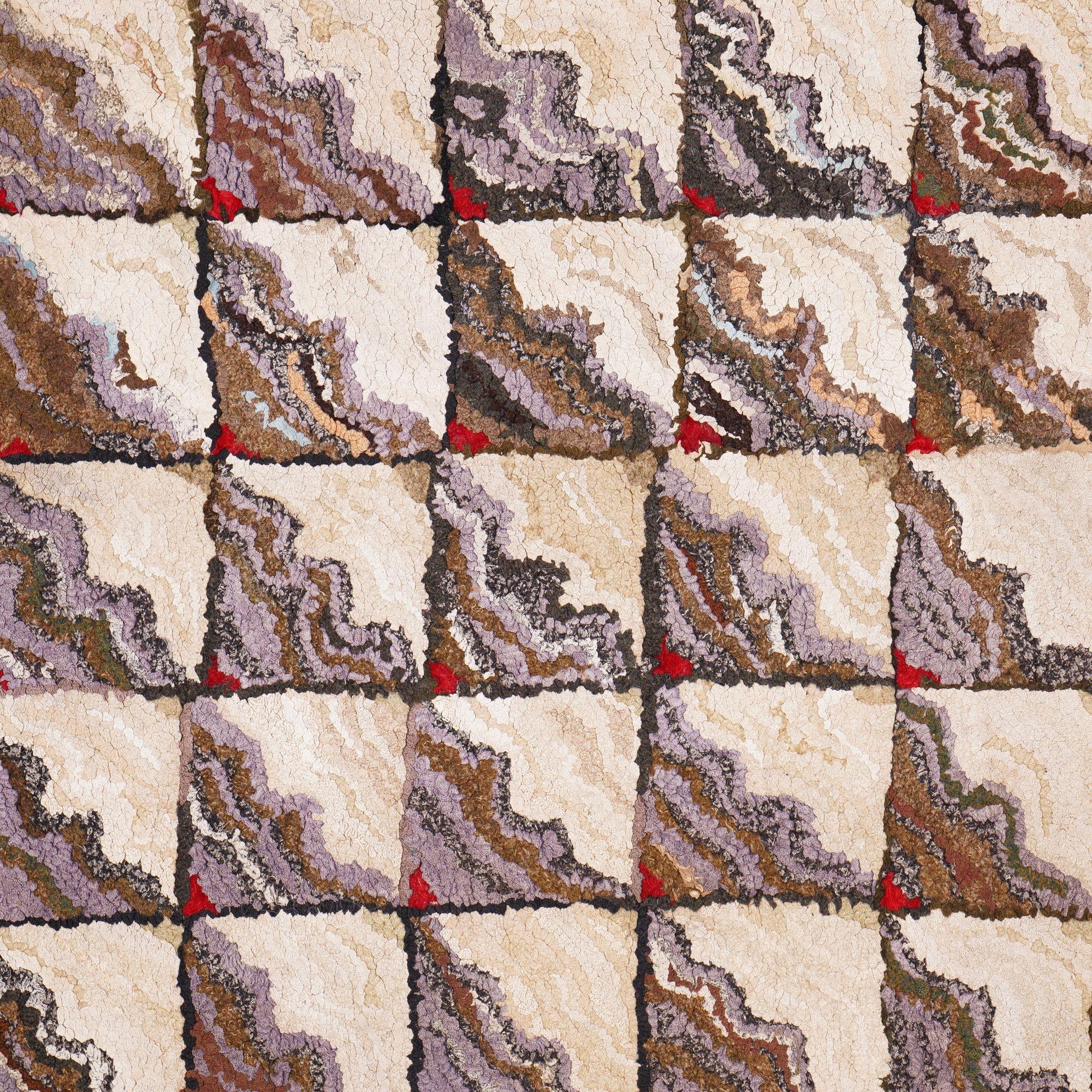 Tapis américain en coton crocheté, tissé à la main, présentant un motif original de carrés coupés en deux sur la diagonale, avec des tons ivoire d'un côté et une palette limitée de bleu poudre, de lavande, de noir, de marron et de rouge. Les motifs