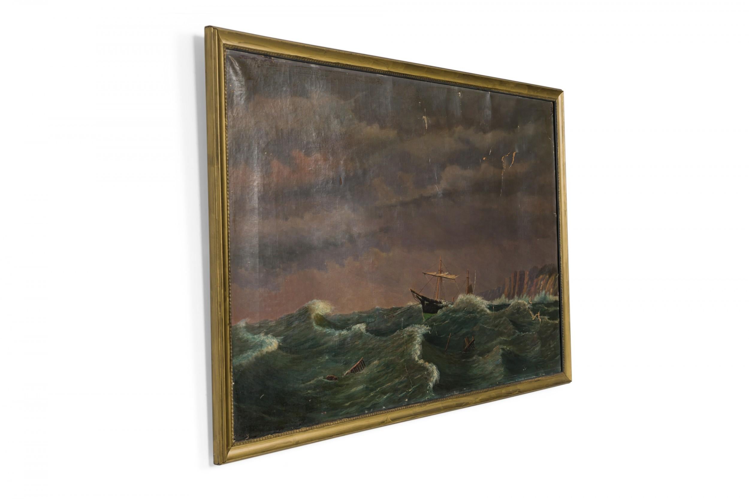 American (19th Century) seascape oil painting in a gold carved frame of a ship foundering in heavy seas with coastal cliffs in the background.