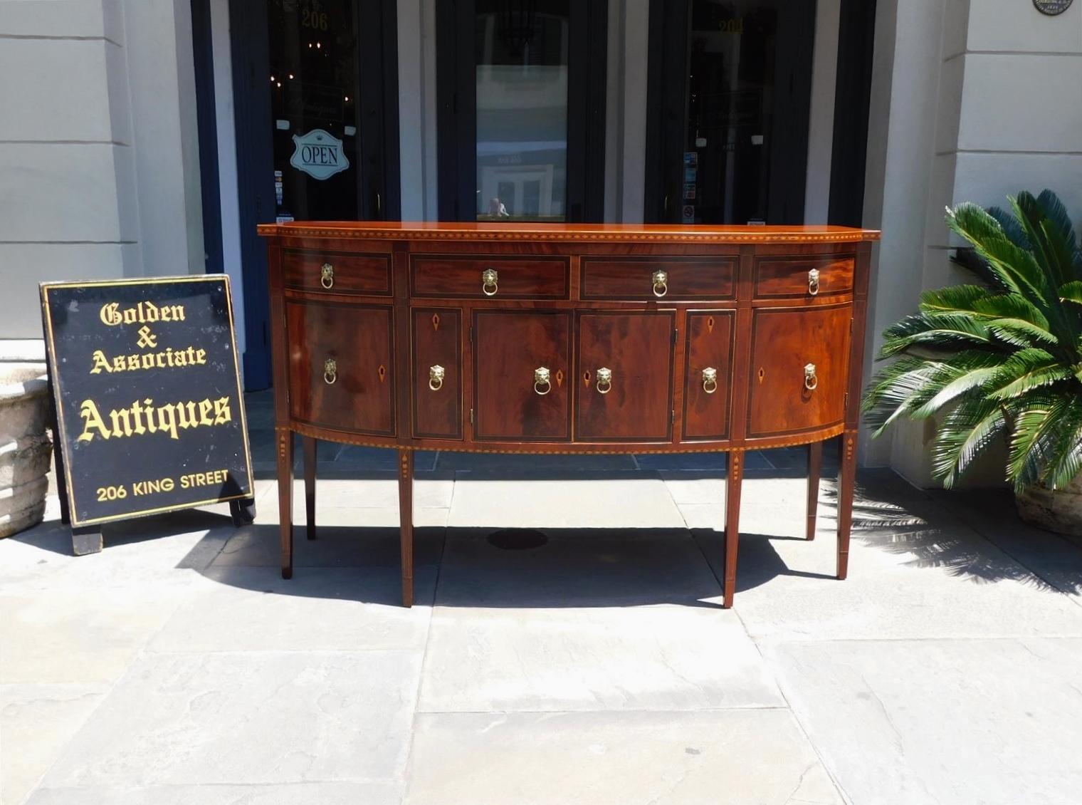 American Hepplewhite Mahogany bow front satinwood string inlaid sideboard cross banded with kings wood, lion head pull brasses, inlaid diamond escutcheons with key, three upper drawers, central hinged cabinet doors flanked by cellarette divider