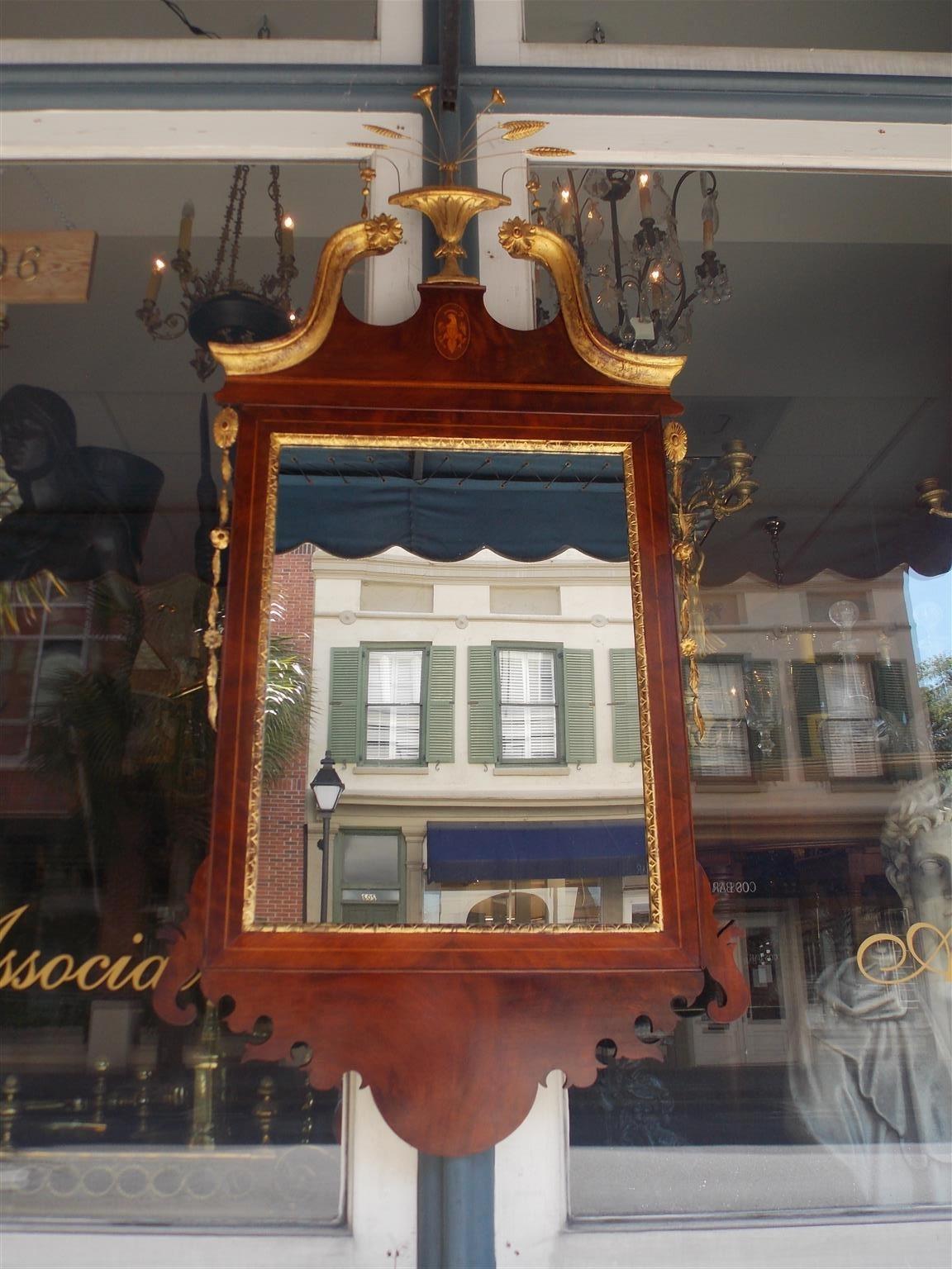 American Hepplewhite mahogany classical mirror with a gilt carved centered urn with thin whispy flowers, gilt scrolled crest with flanking rosettes, oval patera inlaid eagle insignia, holly string inlays, flanking delicately carved gilt medallion