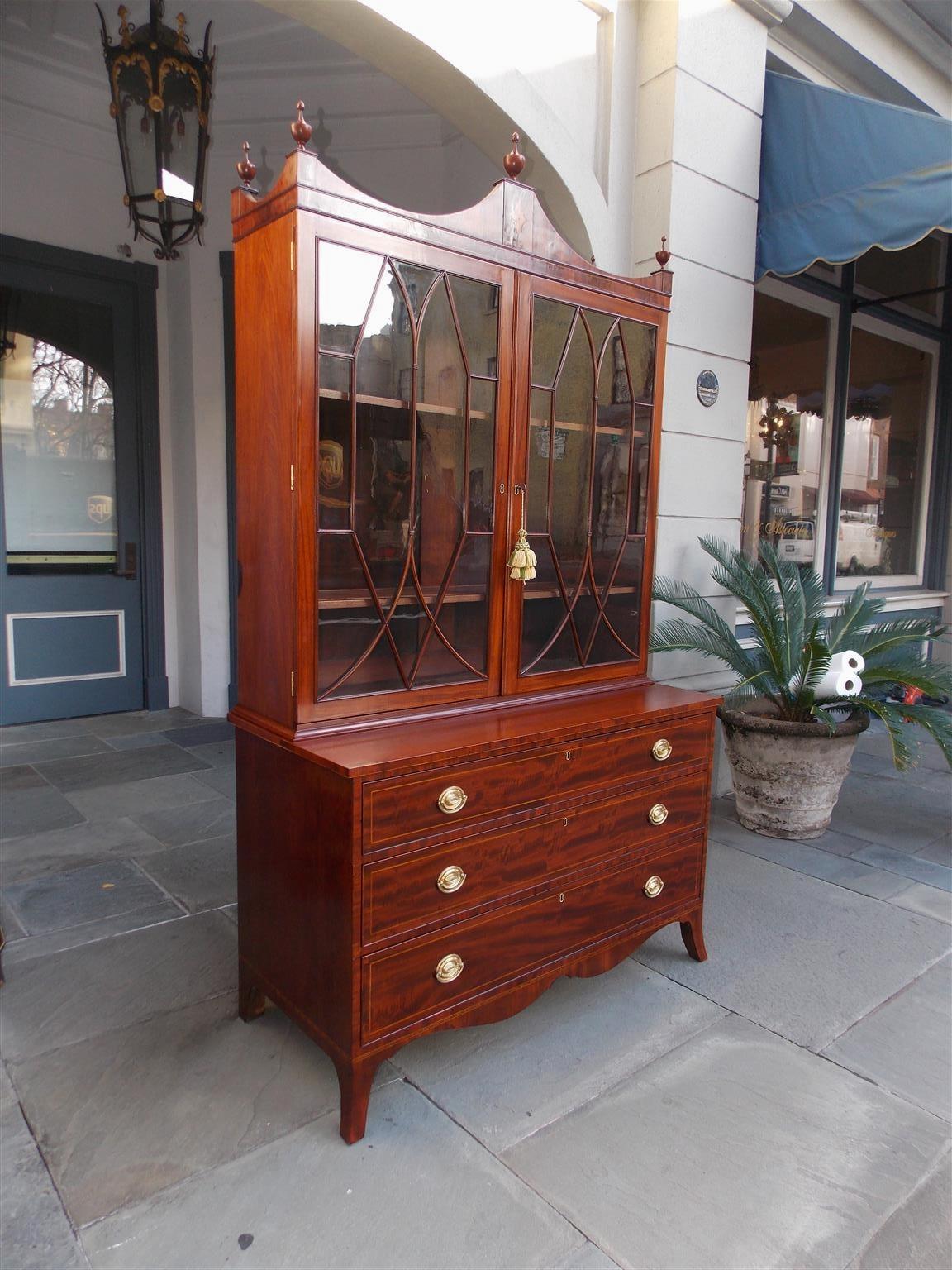 American Hepplewhite mahogany china press with a curvature cornice, flanking urn finials, satinwood inlaid diamond patera, hinged glass mullion doors revealing two adjustable interior shelves, three graduated drawers with the original brasses,