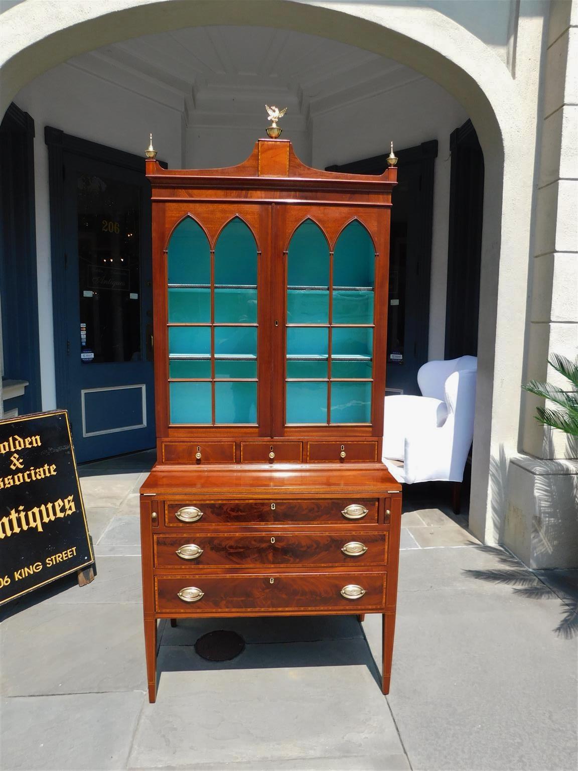 American Hepplewhite mahogany satinwood string inlaid secretary bookcase with a hinged fall front leather writing surface, central arched tulip wood inlaid cornice with original brass urn eagle finials, upper case with flanking hinged glass arched