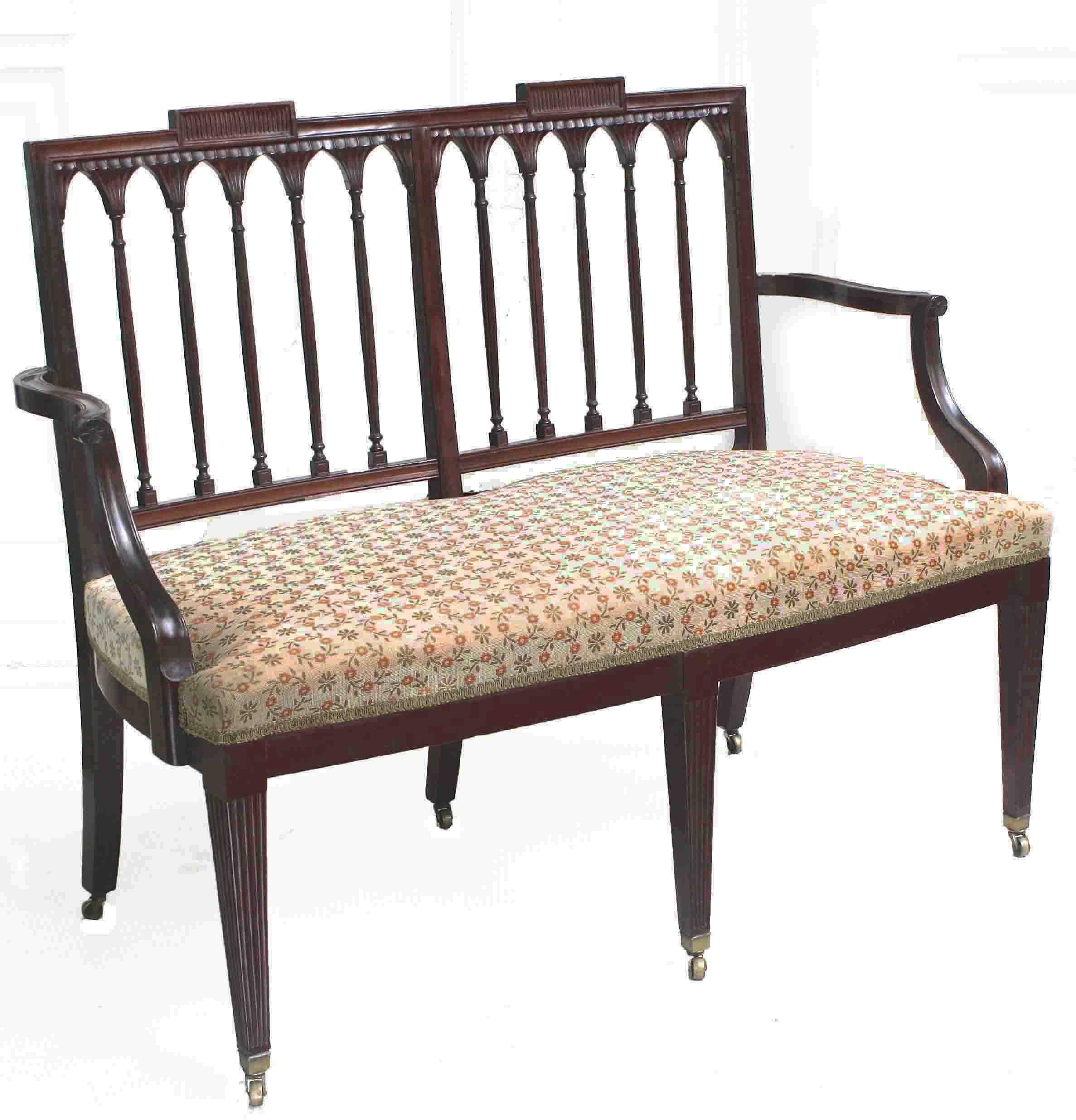 A solid mahogany framed two-seat box upholstered settee with exceptionally fine carved detail, reeded tapering front legs, and brass castered feet. Rhode Island origin and provenance. Ex: same private collection as the concurrently offered set of