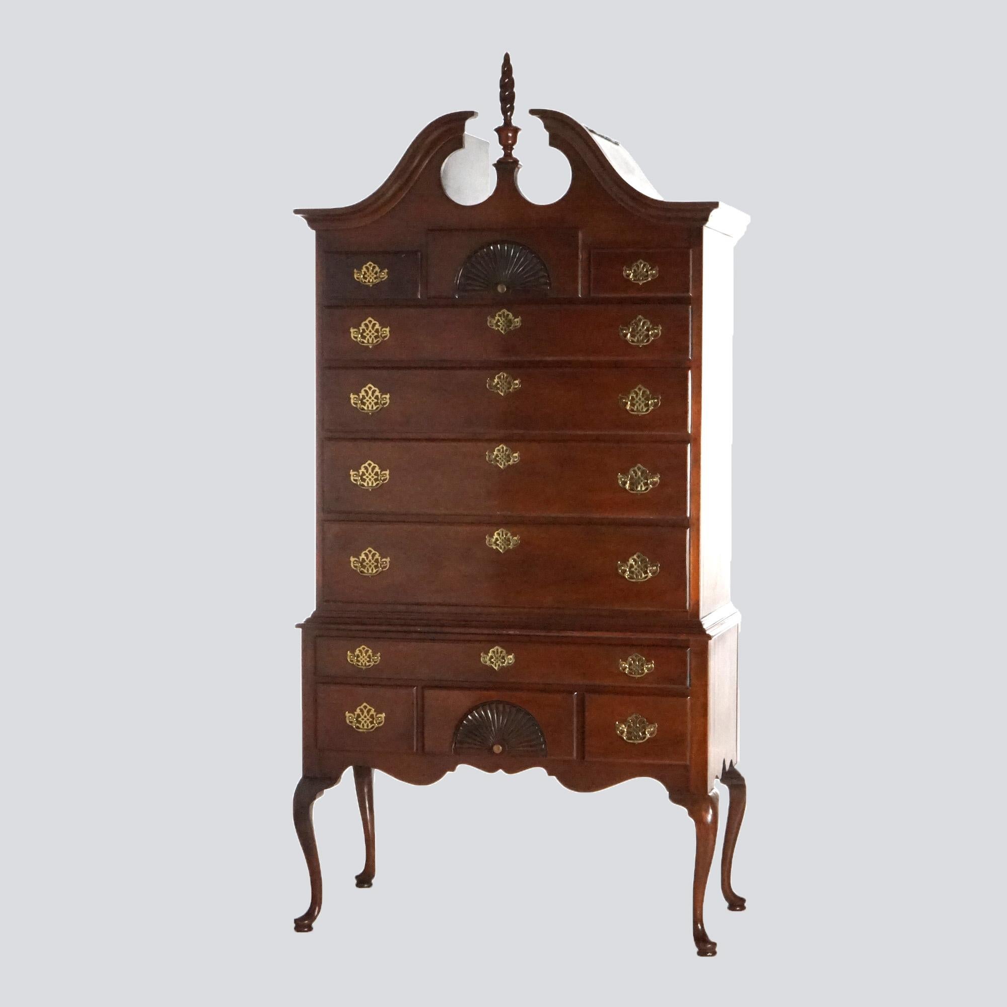 A Queen Anne style chest on chest of the American Heritage line by Hickory offers mahogany construction with broken arch crest having central carved flame finial over case have carved shell decoration and graduated drawers; lower chest with drawers