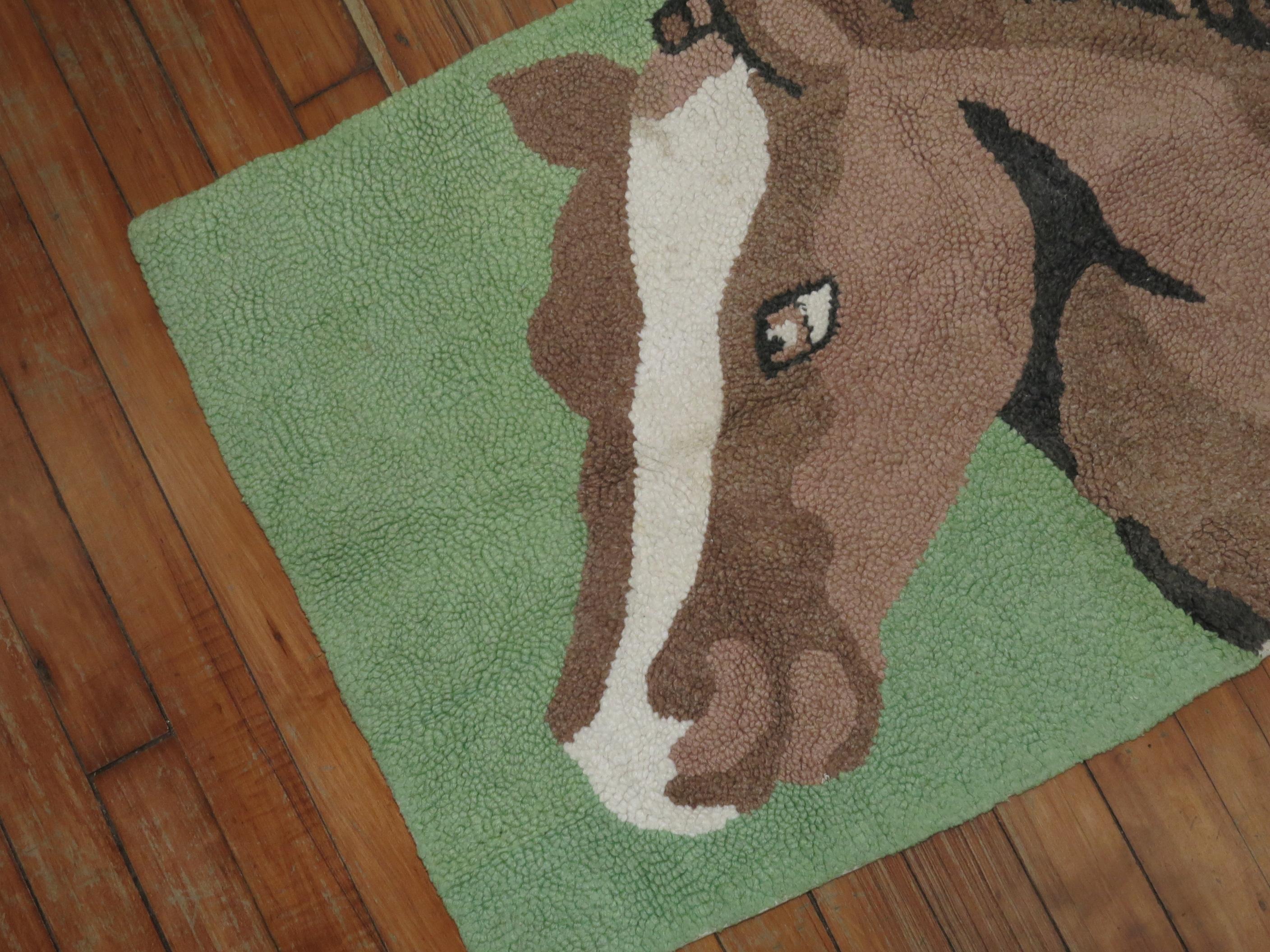 A handmade American hooked rug from the middle part of the 20th century depicting a horse on a mint green background. Condition is really nice. No stains, no tears, has been professionally cleaned.