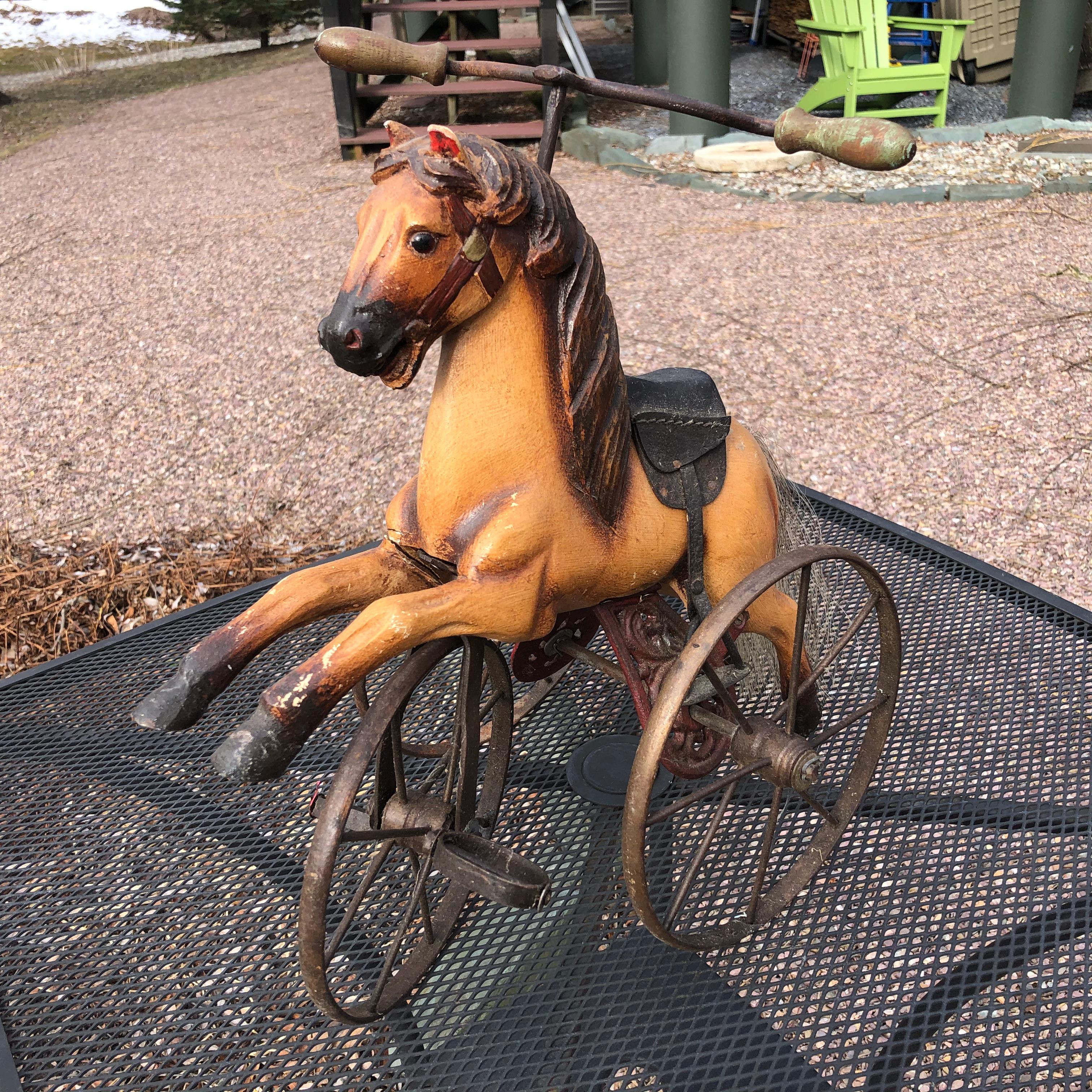 An American horse tricycle, handcrafted in wood and metal, works well.

Likely imported into the United States and created in the Philippines in the late 20th century. 

Dimensions: 16 inches high and 15 inches wide and 8 inches deep

Hand