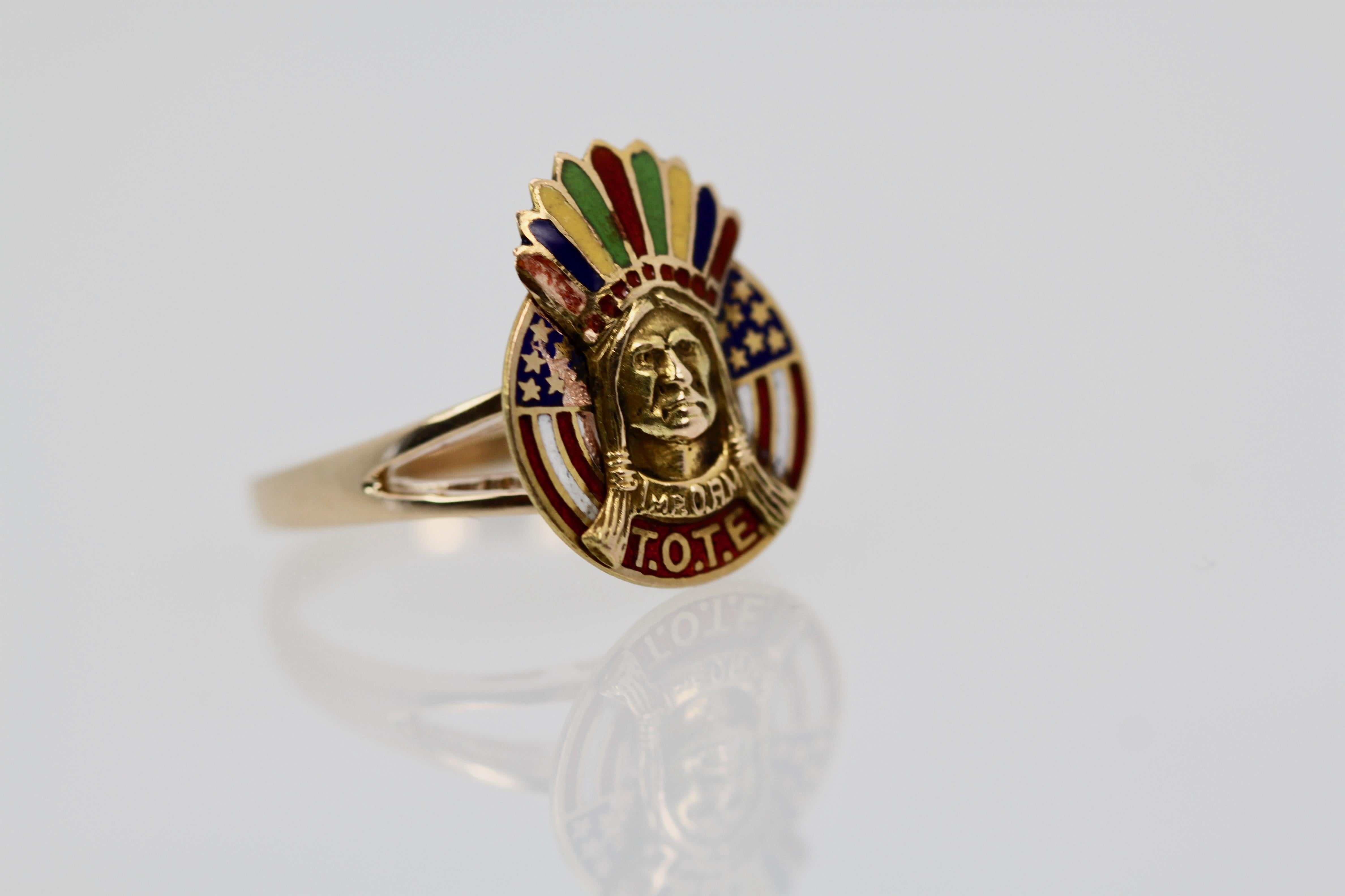 American Indian Enamel ring in 14K Gold depicts an American Indian chief in full feather head dress. This was at one time a stick pin which I converted to a ring. This Indian sits with an American Flag behind it. There is some enamel loss to one