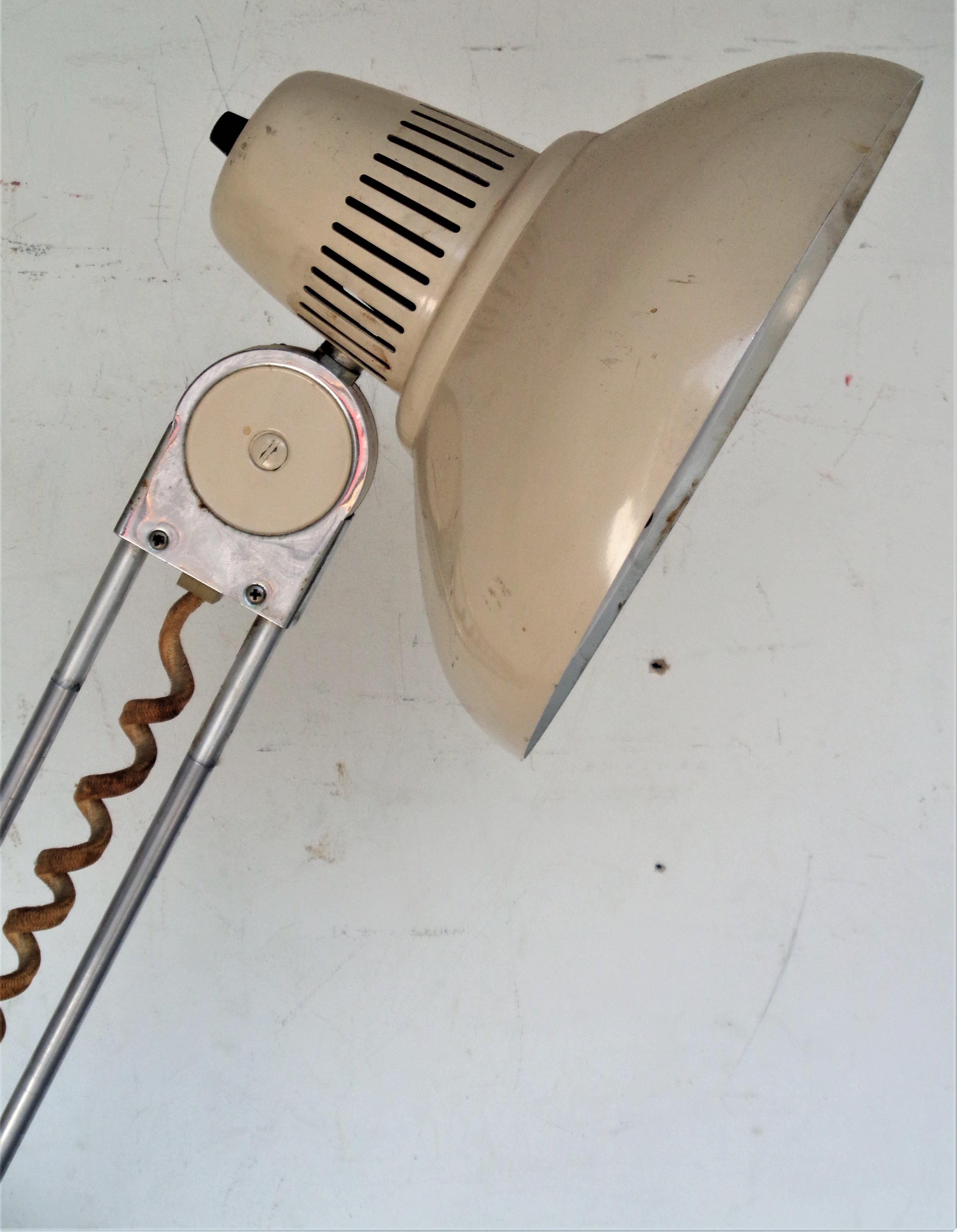 Lampe de table pivotante télescopique industrielle américaine en métal et aluminium avec une base de 8 pouces de diamètre qui est lestée de fer sur la partie inférieure et la finition d'usine originale en émail peint sur le métal. La hauteur
