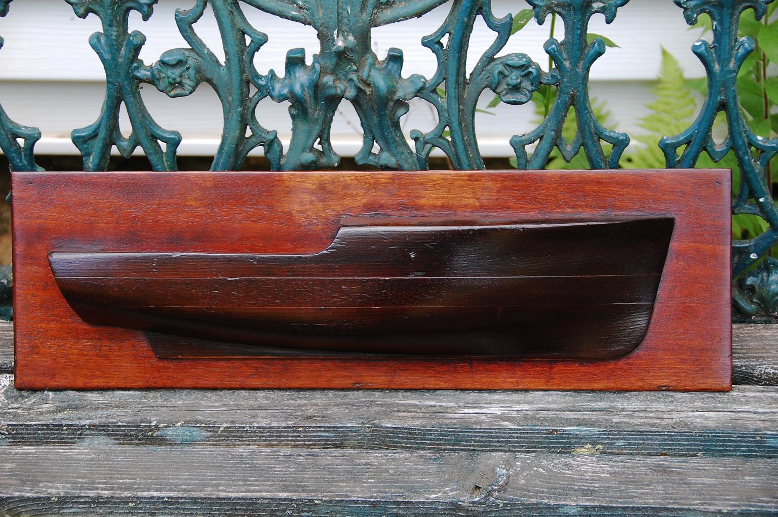 American late 19th to early 20th century planked half hull model of a raised deck cruiser on its original mahogany back board This small half hull model easily melds into a collection of marine paintings or sculptures as it is only 21 inches long