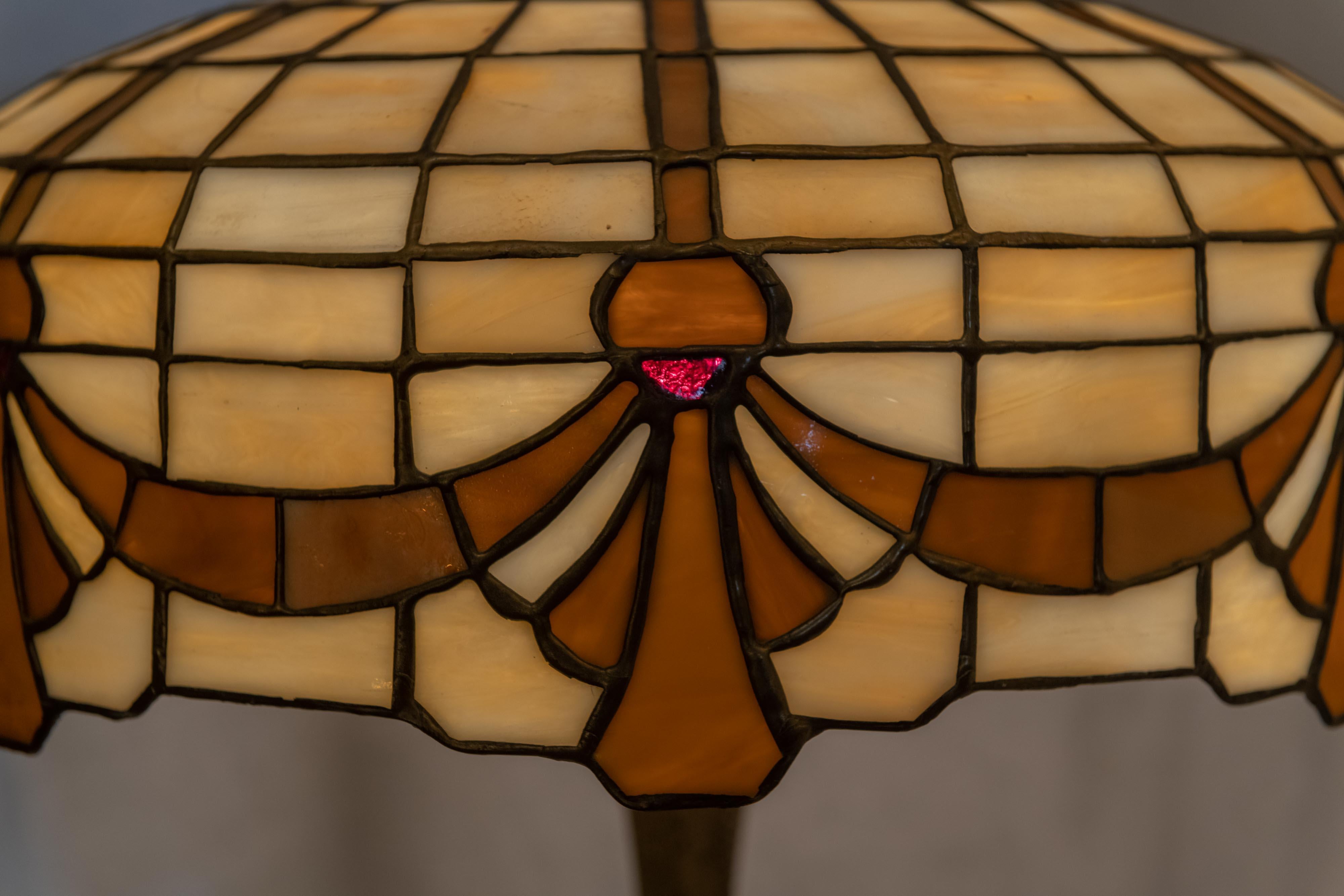 We like to specialize in leaded glass table lamps, and have been doing so for over 35 years. This simple, yet attractive lamp was done by Lamb Bros. How do we know ? We just know. We have actually owned one of these several years ago. The base is
