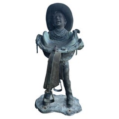 Vintage American Life Size Bronze of a Young Boy Holding a Saddle