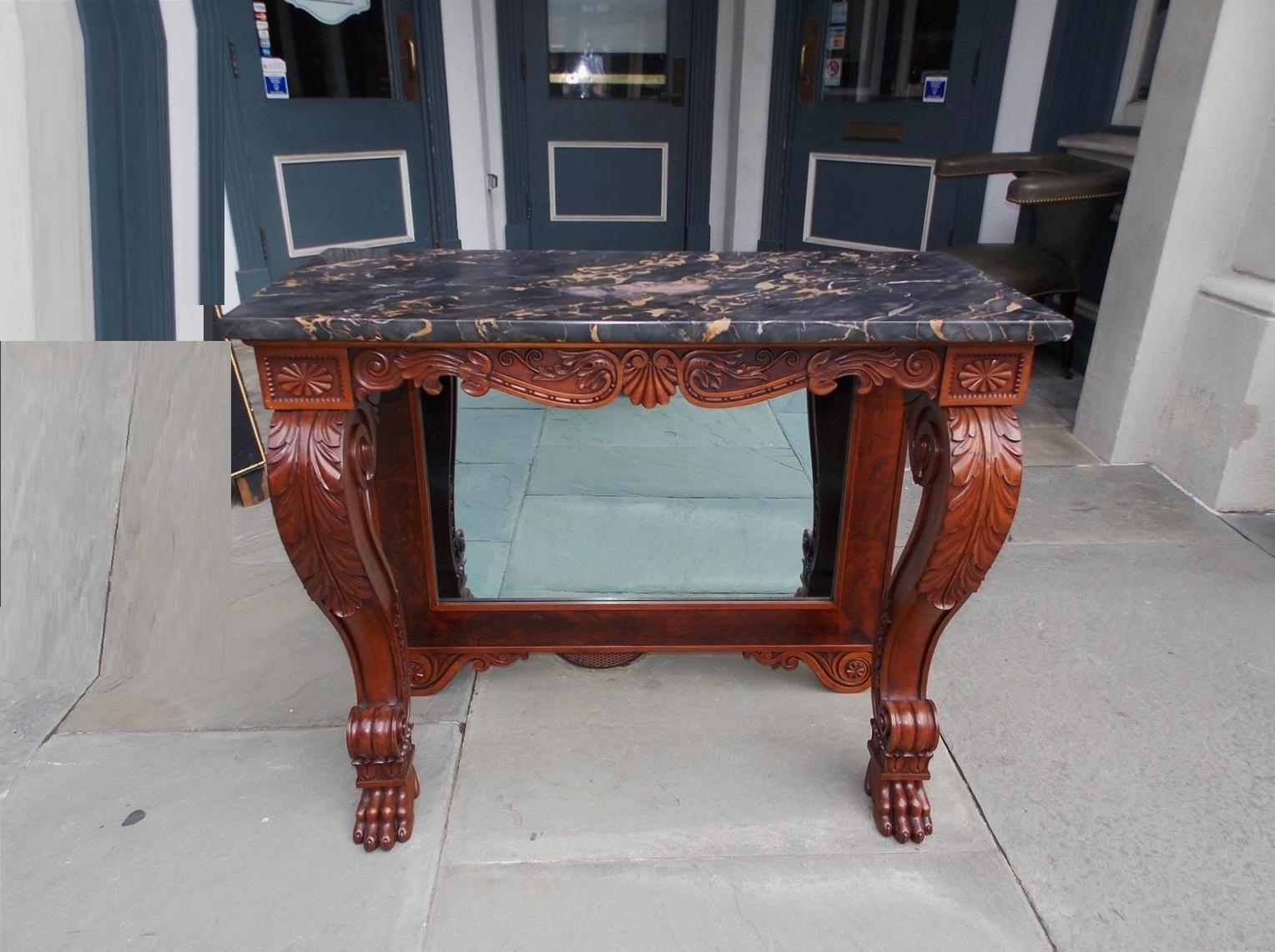 American mahogany marble-top console / pier table with acanthus scrolled legs, flanking corner beaded medallions, decorative scrolled acanthus skirt with centered shell motif, original mirror with wood backing and resting on carved lions paw feet,
