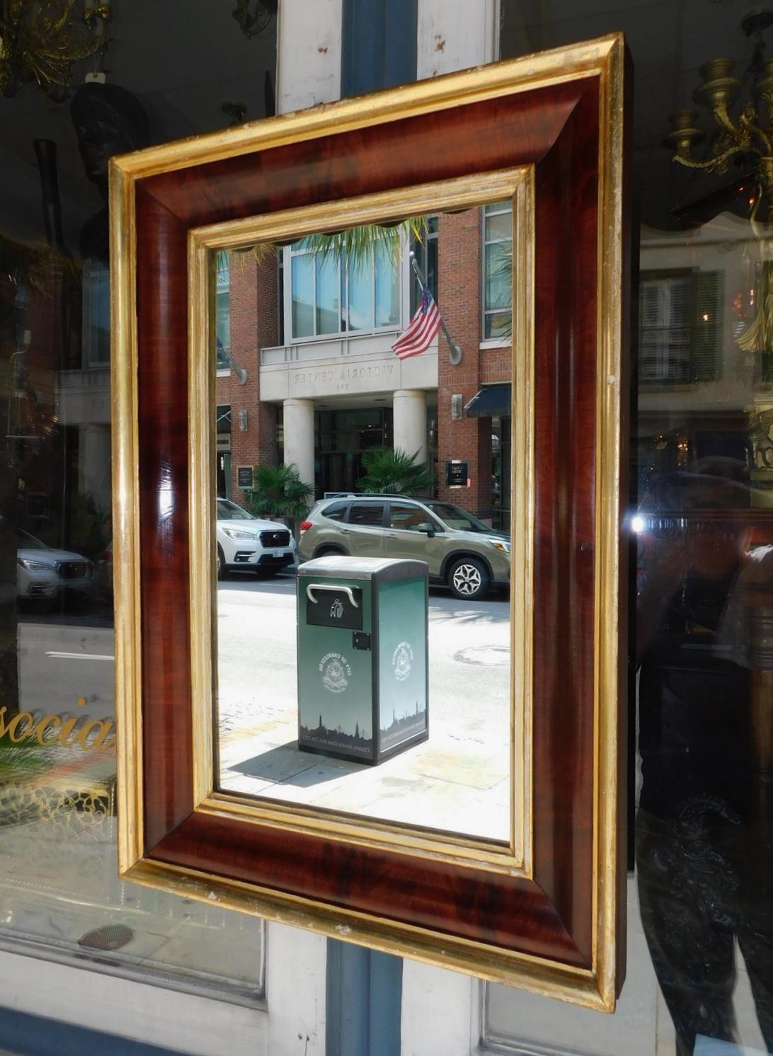 American mahogany and gilt wood ogee wall mirror with the original glass and wood backing. Early 19th century.