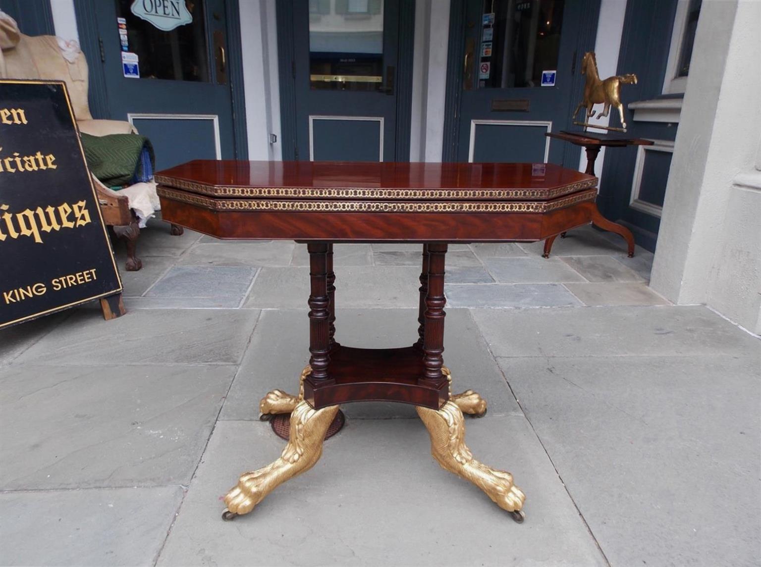 American Federal mahogany hinged game table with intricately articulated brass inlay, swivel top revealing compartmentalized interior, four supporting turned bulbous ringed columns, and terminating on gilt acanthus hairy paw lions feet with the
