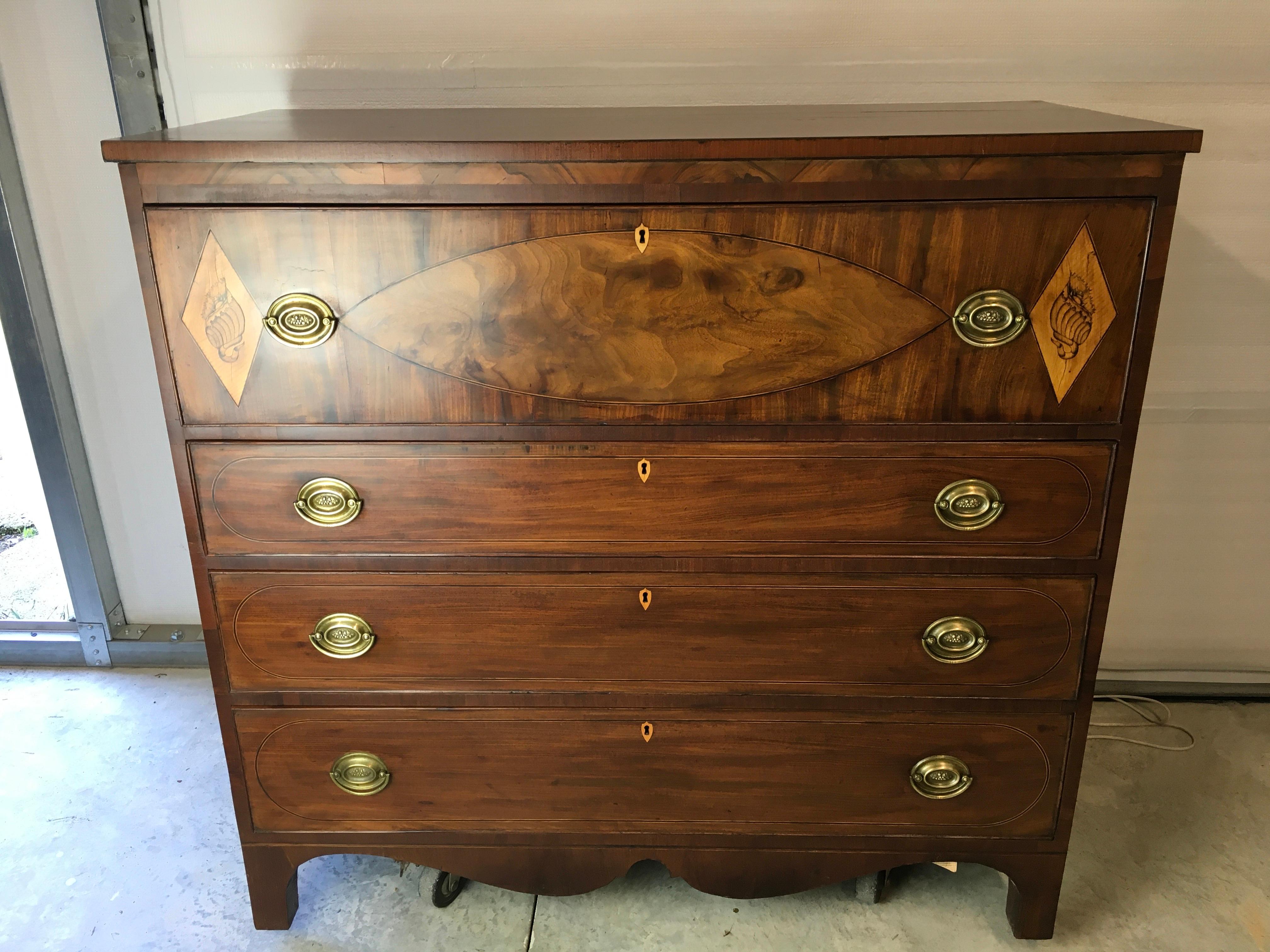A very nice American Hepplewhite Mahogany chest probably of New England origin around 1800-1820. This piece has beautiful oval string inlay banding around the drawer fronts and a large figured Mahogany oval veneer inlay on the large top drawer