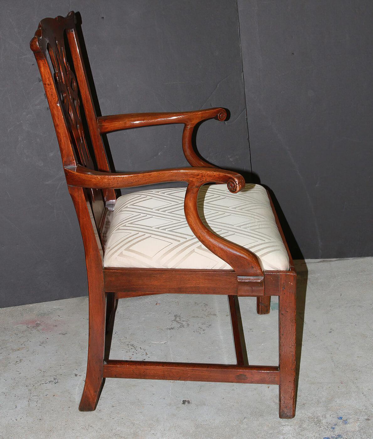 An American mahogany Chippendale armchair with scrolled carved ears, scrolled arms, a scalloped apron, and an H stretcher base.

Dimensions: 28
