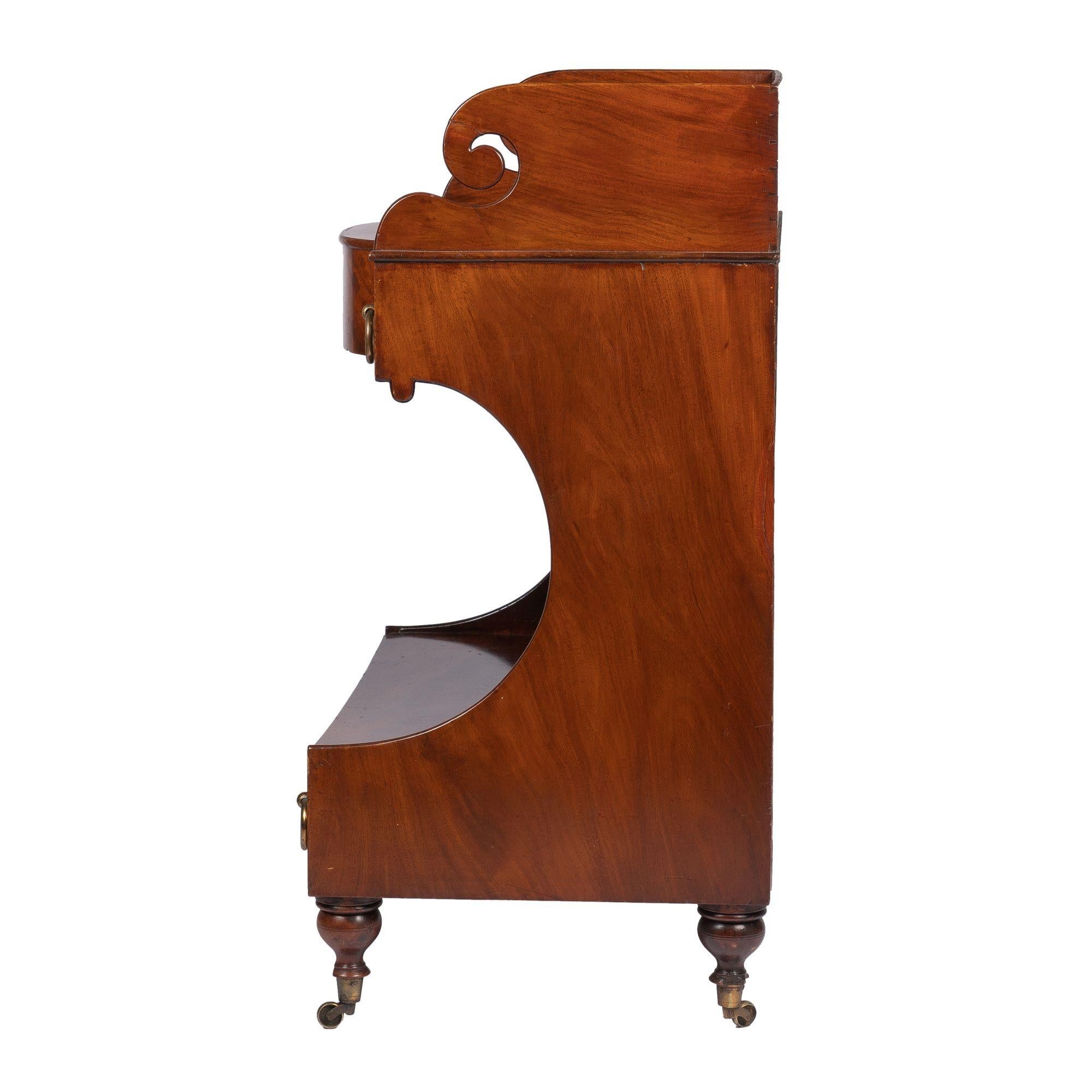 American neoclassic dressing stand / wash stand with projecting demilune top, framed on three sides with a splash. The top rests on a conforming apron fitted with flanking apron drawers accompanied by drop ring brass pulls, and is supported by an