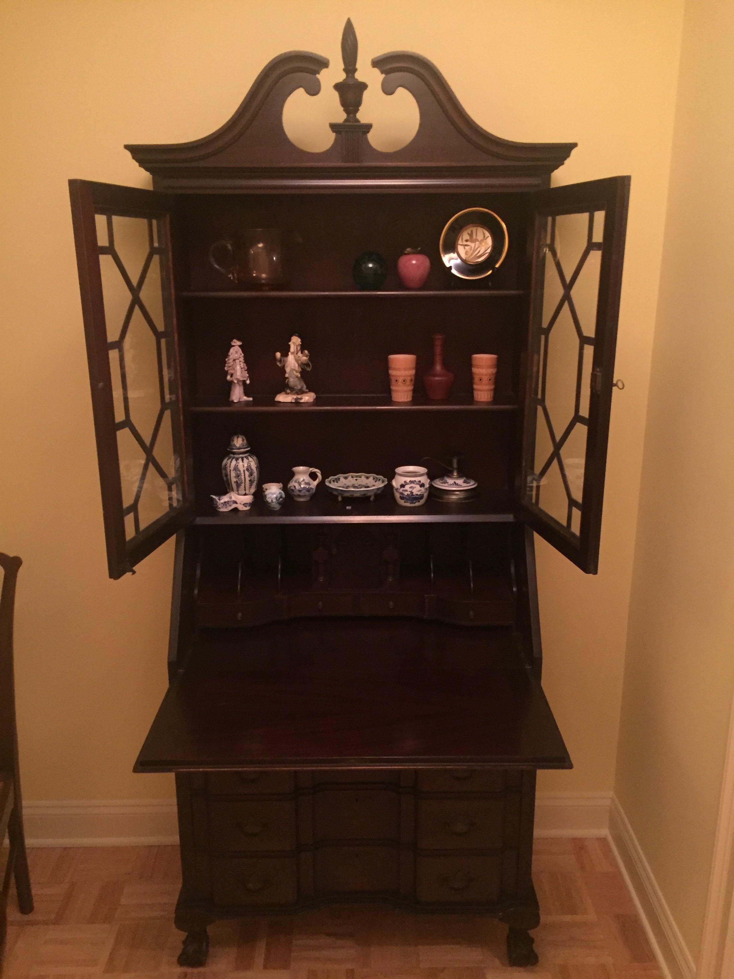 Classic American mahogany block front secretary desk. The glass doored top with swan neck pediment resting on a four drawered fall front desk with Chippendale feet.