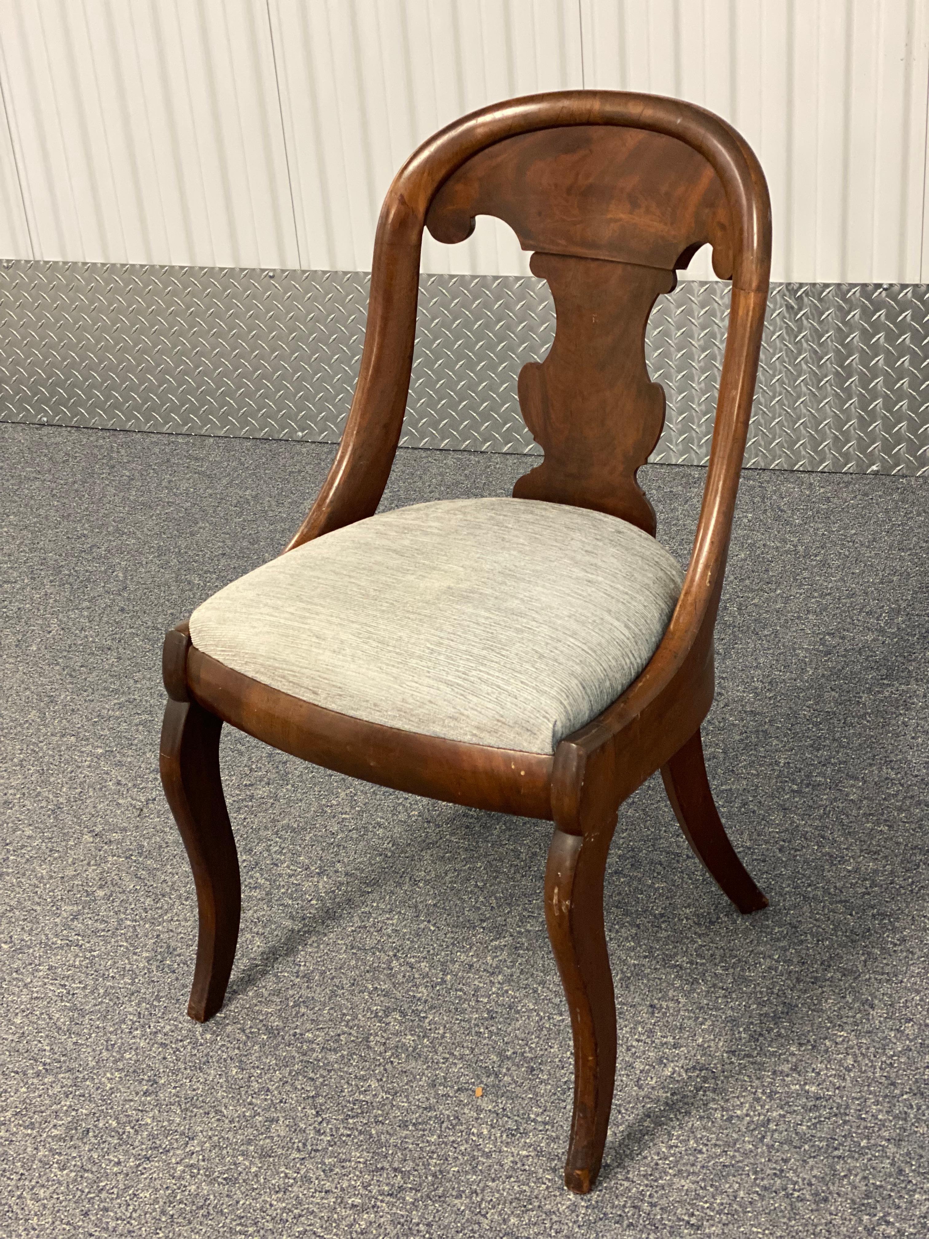 American Mahogany Gondola Chair, c. 1815
This American Mahogany Gondola Chair features a boxed slip seat & single vertical baluster form silhouette back splat below a crest rail. The back is defined by a continuous bull nose molding encompassing the