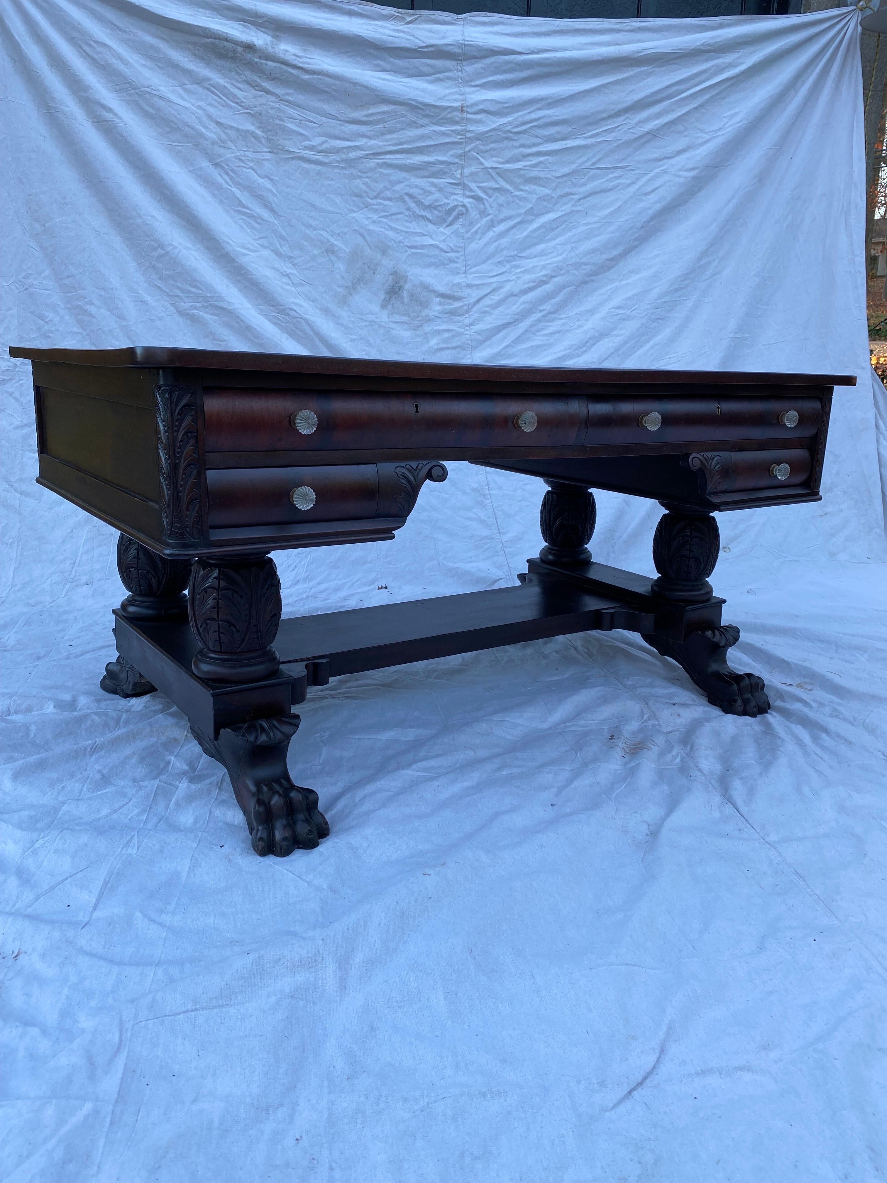 Beautiful Mahogany Partner's Desk with glass knobs. Top refinished and everything else cleaned and ready to go! Two wide drawers per each side with smaller drawers below. Beautiful carved Lion's Paw feet. Ball glides make it easy to move desk when