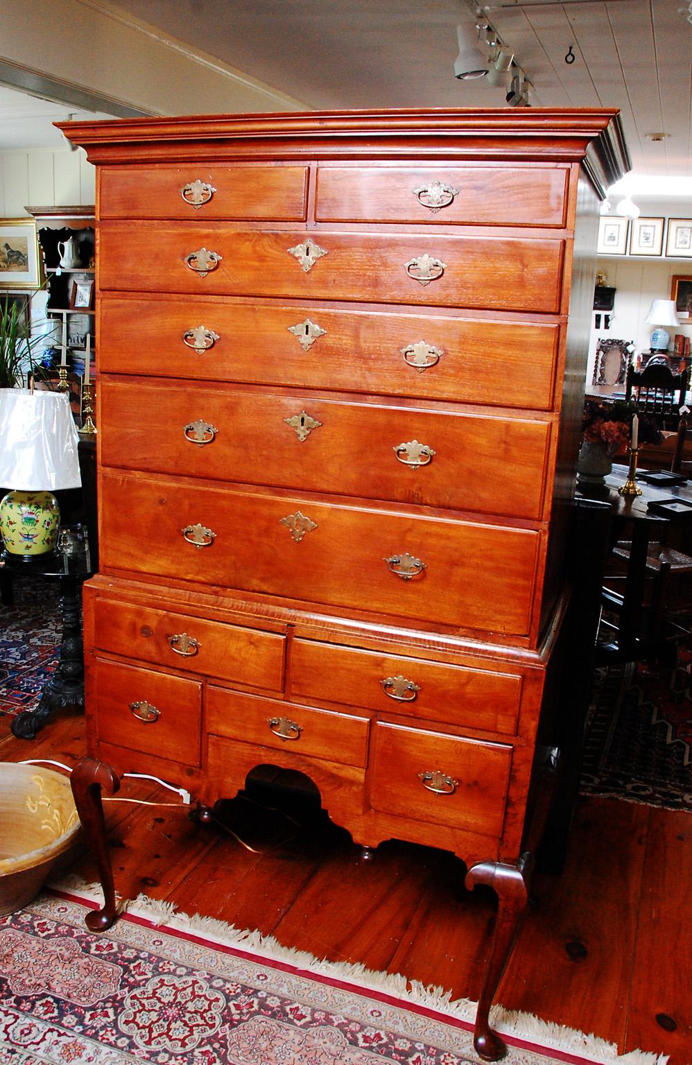 American Queen Anne Massachusetts maple two part highboy with cabriole legs, pad feet, shaped skirt and bold cornice. The molding that holds the upper section in place is in curly maple, a nice contrast to the straight maple in the rest of the