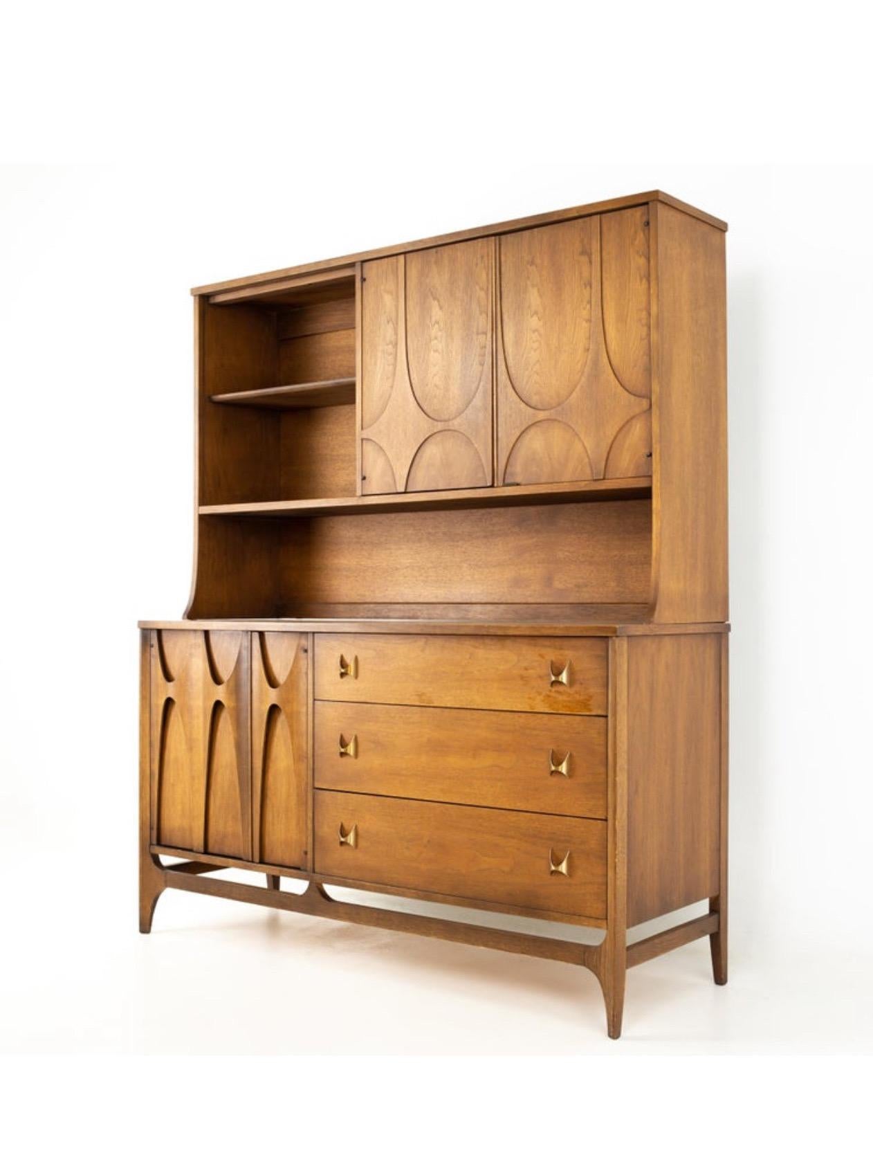 Iconic American MCM walnut Brasilia Collection sideboard / credenza / hutch by Oscar Niemeyer for Broyhill, cira 1960s.  The piece is in very good original condition complete with glass sliding door and brass hardware.  Very rare and hard to find