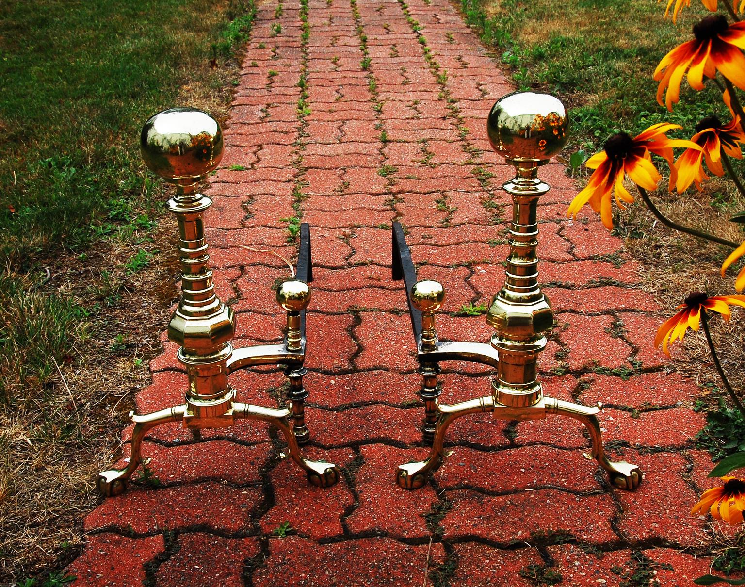 American cast brass mid 19th century Andirons of unusual pattern. These bold 20 1/2 inch high ball top andirons are distinguished by having a column, often referred to as a beehive column, which supports the ball tops. This unusual column sits on