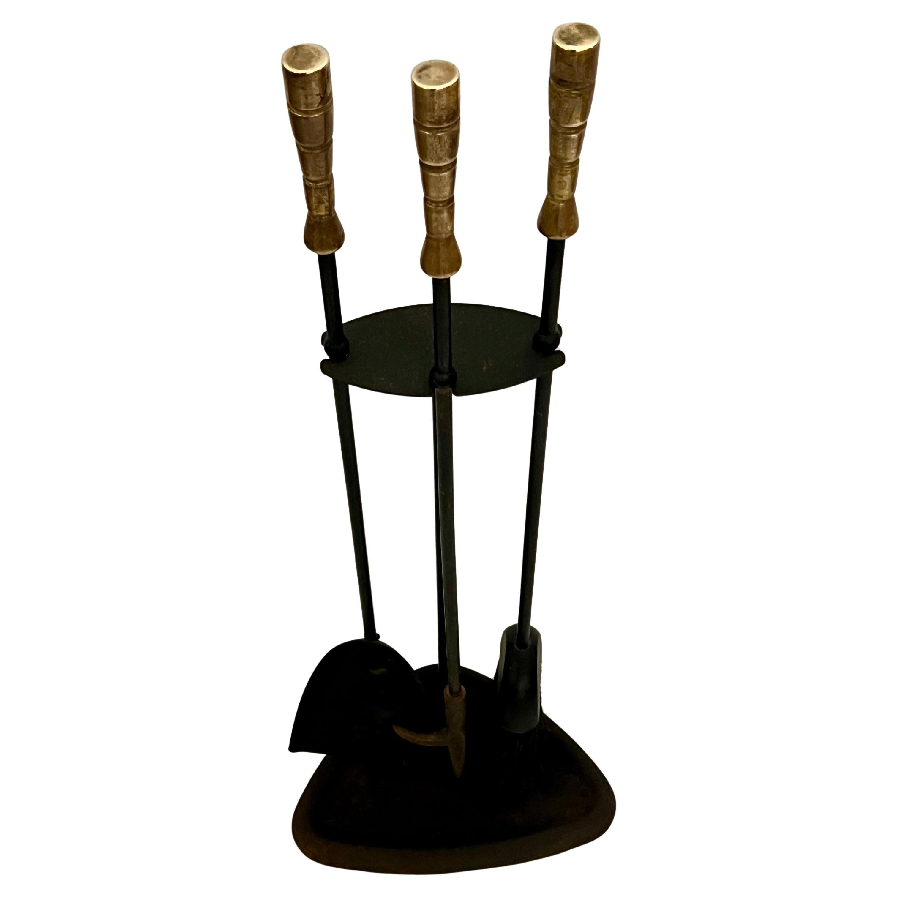 A classic American mid-century atomic age iron and brass fireplace tools set with solid patinated brass handles, circa 1950's.  The set is in good vintage condition.  