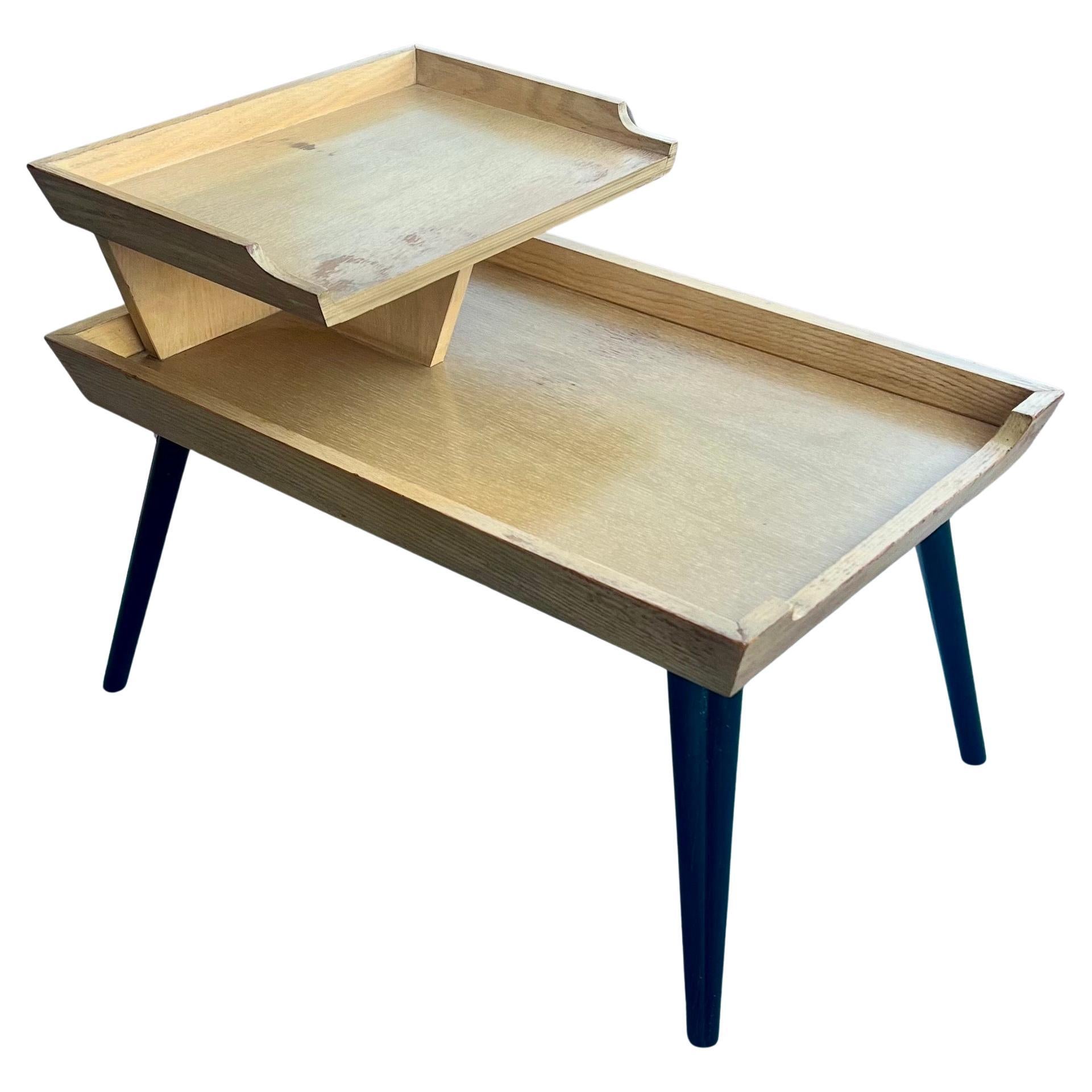 A classic American Mid Century step end table , incredible lines and quality the legs are put togoether with no screws , it has a bleached mahogany finish with black lacquer legs, original finish looks great as ais but its sold as/is condition. 