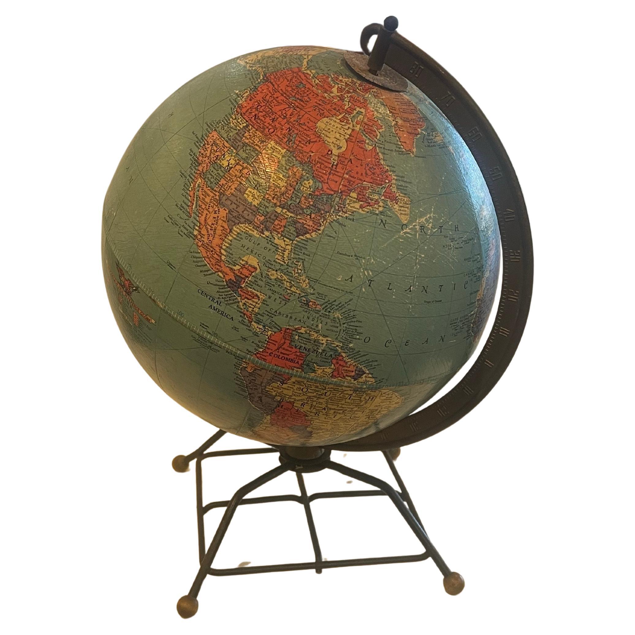 A very rare mid century modern atomic age Replogle Globe , sitting on and iron base with solid brass patinated feet very hard to find , original condition and patina , circa 1950's some fading and wear as shown .